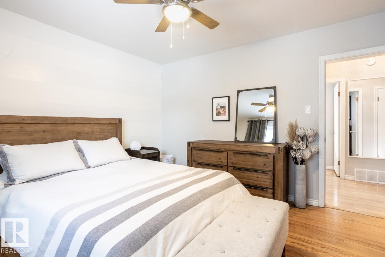 Bedroom featuring light wood-finish flooring and a ceiling fan with integrated lighting - 8239 93A Avenue, Edmonton, AB - Indoor Photo Showing Bedroom