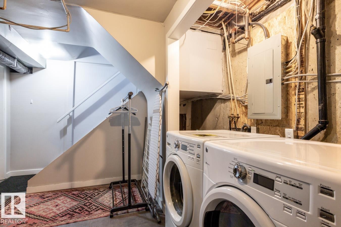 Dedicated laundry area with a washer and dryer, located near a finished stairway - 8239 93A Avenue, Edmonton, AB - Indoor Photo Showing Laundry Room