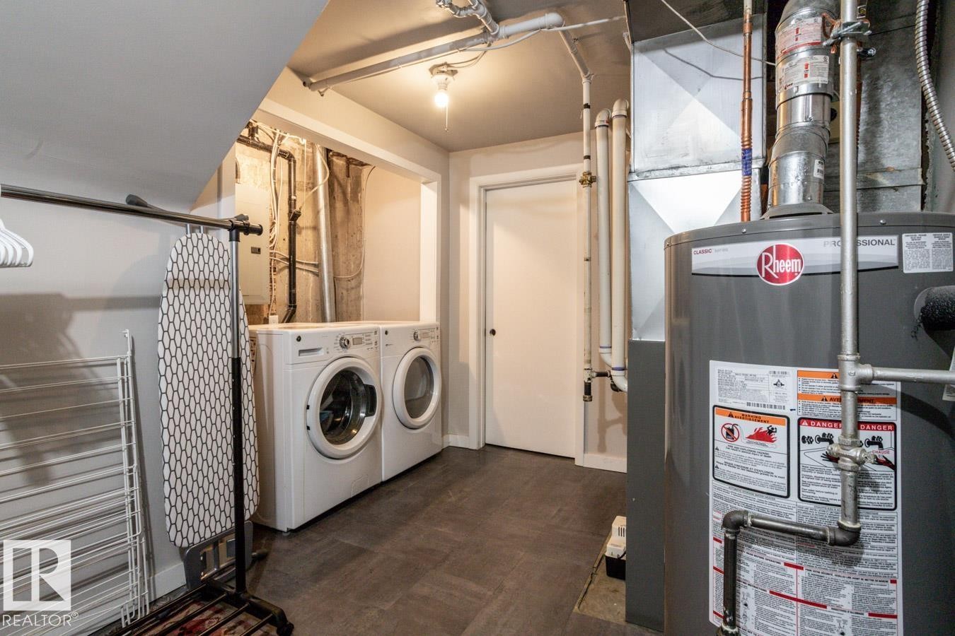 Laundry area featuring a side-by-side washer and dryer, tile-finish flooring, a white door, and visible utility infrastructure - 8239 93A Avenue, Edmonton, AB - Indoor Photo Showing Laundry Room