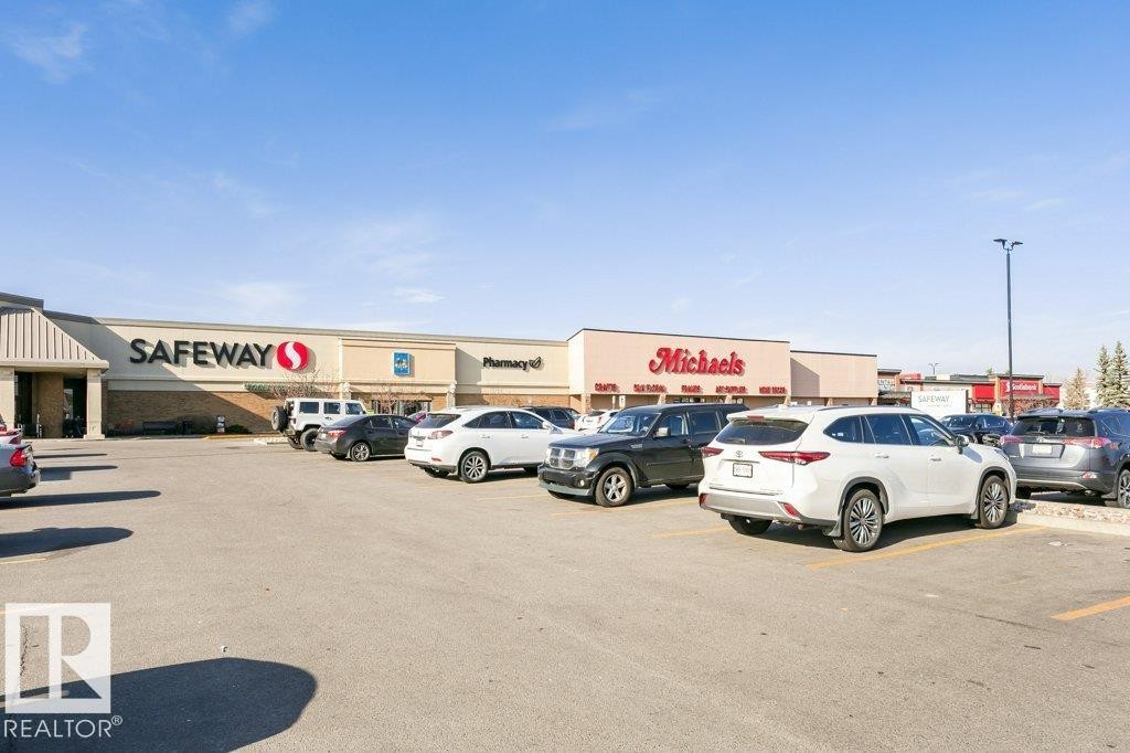 Retail plaza featuring Safeway and Michaels storefronts, expansive paved parking lot, and clear signage - 323 16807 100 Avenue, Edmonton, AB - Outdoor