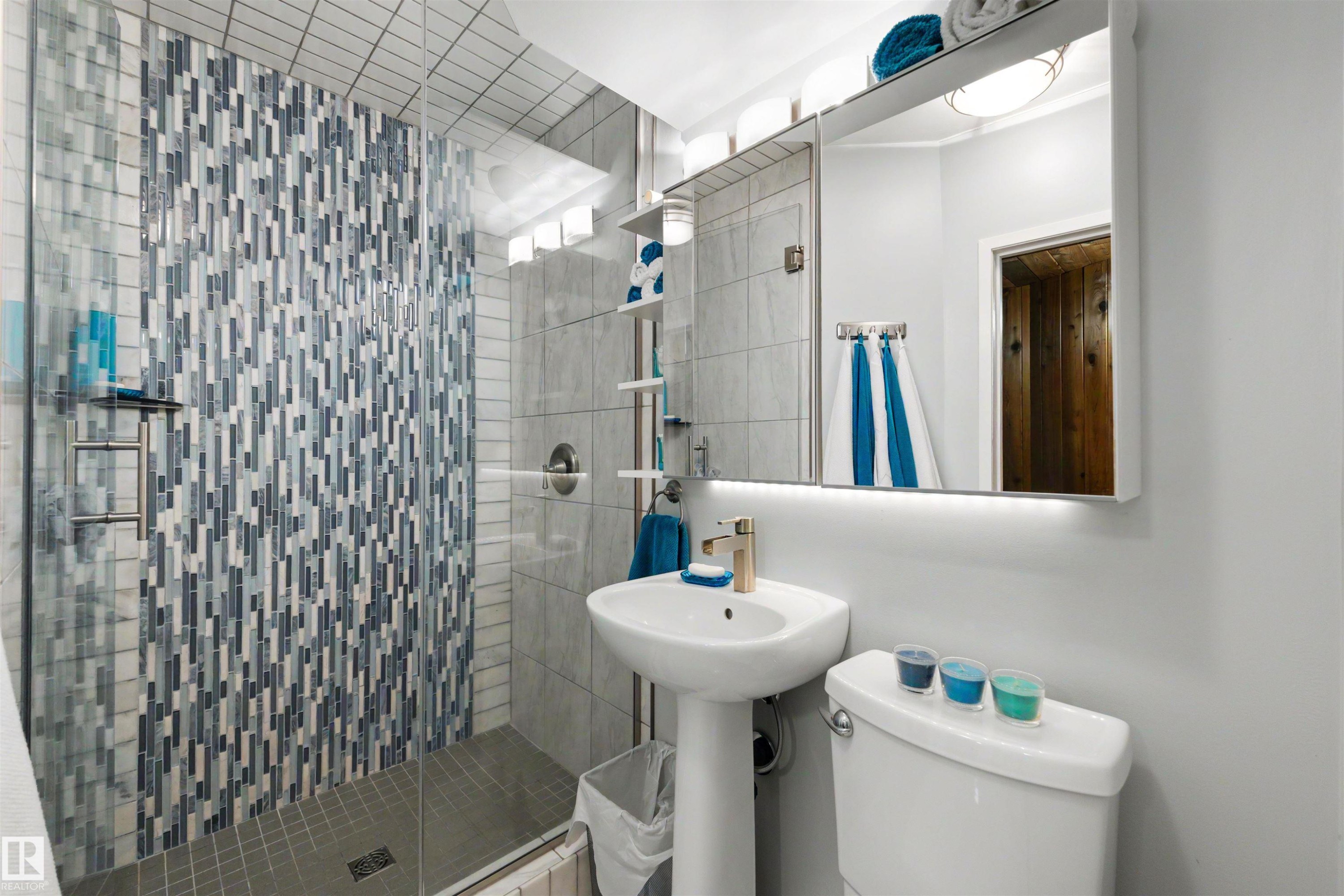 Glass-enclosed shower with mosaic tile surround and built-in shelving - 9602 85 Street, Edmonton, AB