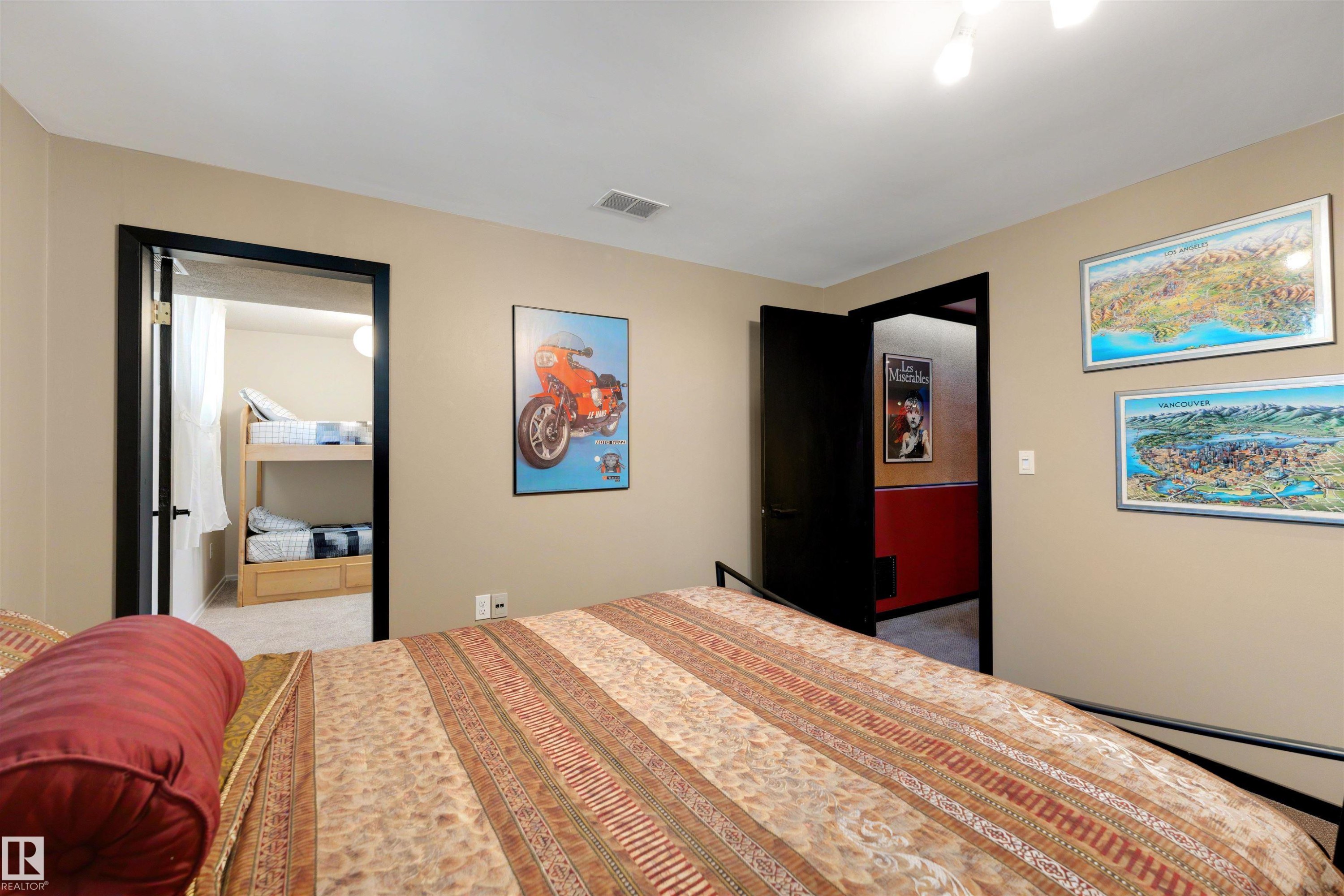 Bedroom featuring neutral-toned walls, a textured carpet, and black trim doors - 9602 85 Street, Edmonton, AB