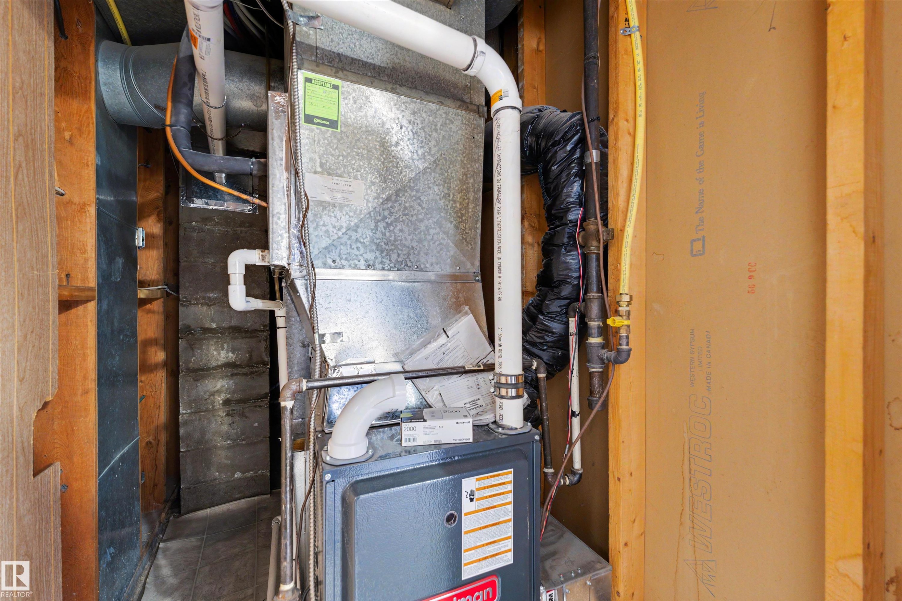 Goodman furnace with exposed ductwork, PVC piping, and copper lines - 9602 85 Street, Edmonton, AB