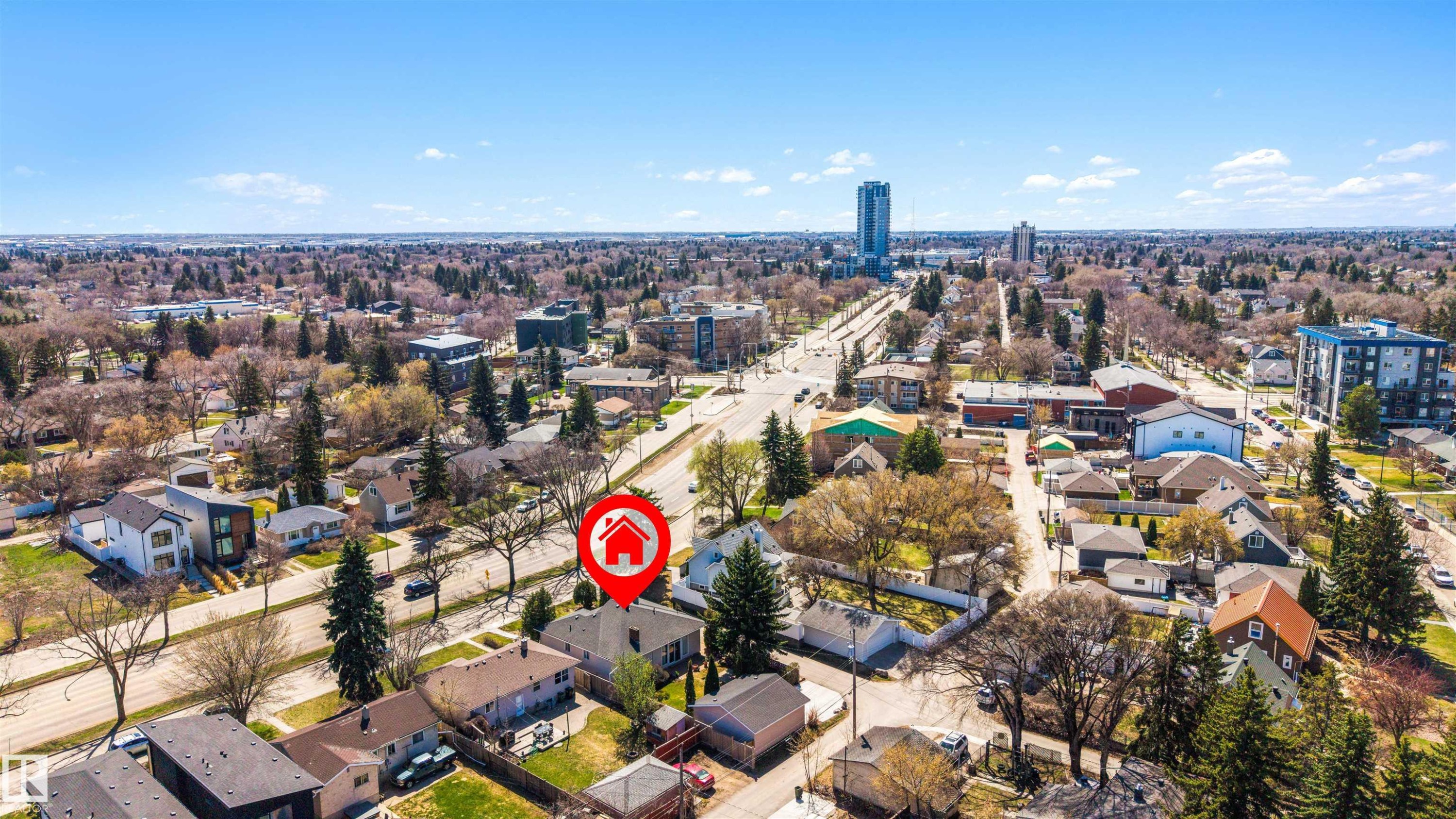 Aerial perspective showcasing a residential area with varied architectural styles, mature trees, and a clear sky backdrop - 9602 85 Street, Edmonton, AB