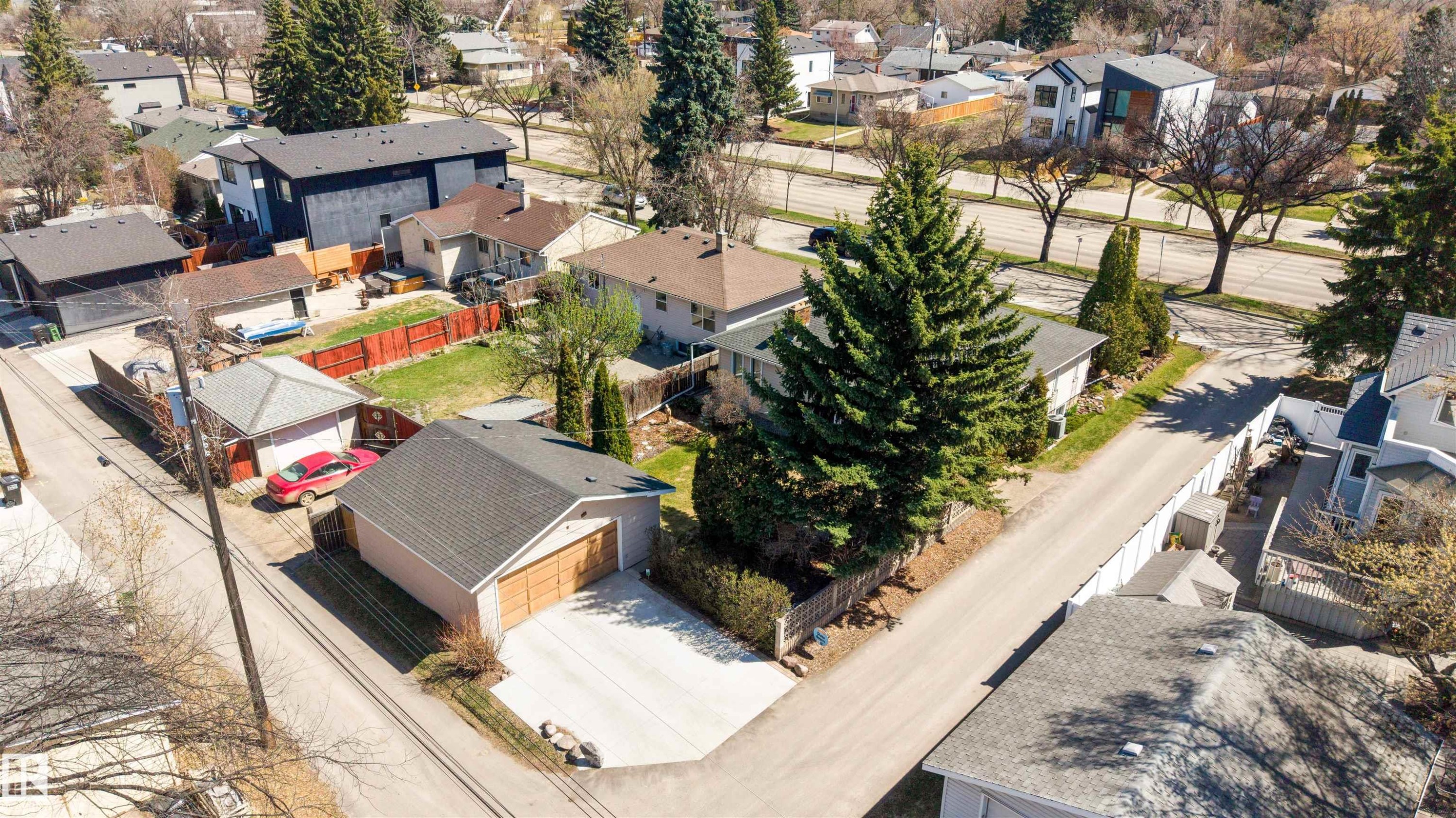 Detached garage featuring wood-finish garage doors and a concrete driveway - 9602 85 Street, Edmonton, AB