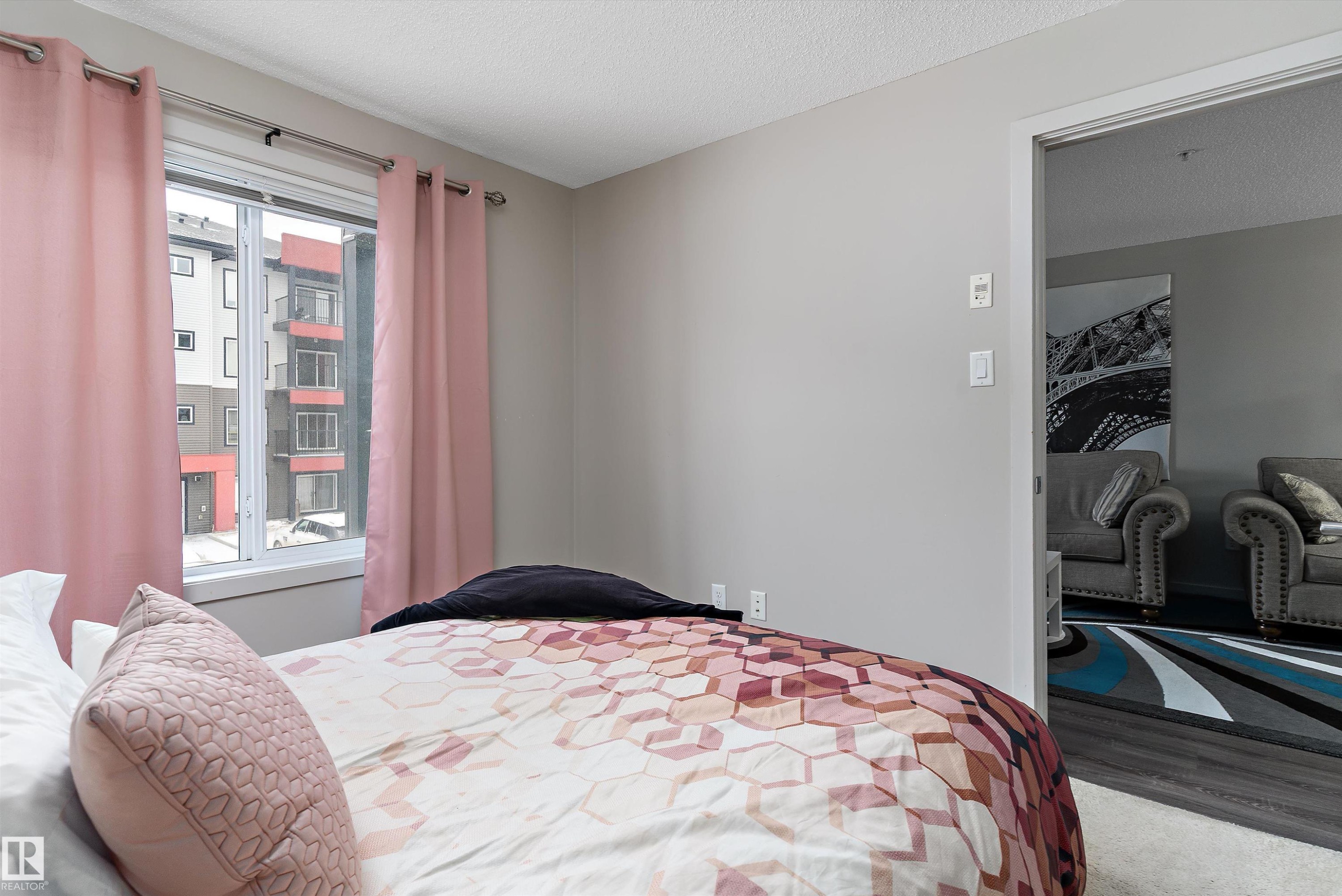 Bright room with a window providing natural light, light gray painted walls, and textured ceiling finish - 231 344 Windermere Road, Edmonton, AB - Indoor Photo Showing Bedroom