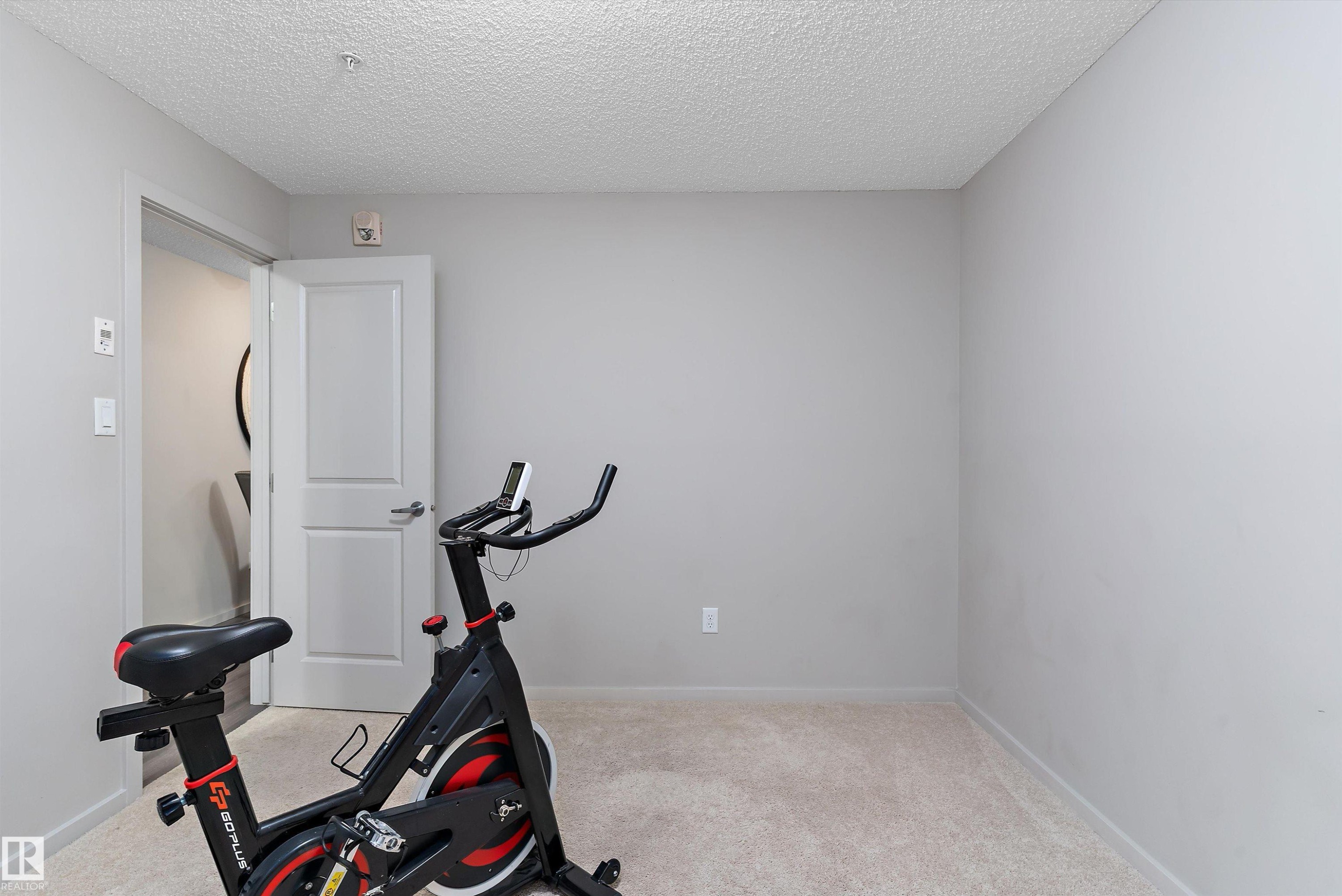 Neutral-toned room featuring light-colored carpeting and smooth, painted walls - 231 344 Windermere Road, Edmonton, AB - Indoor Photo Showing Gym Room