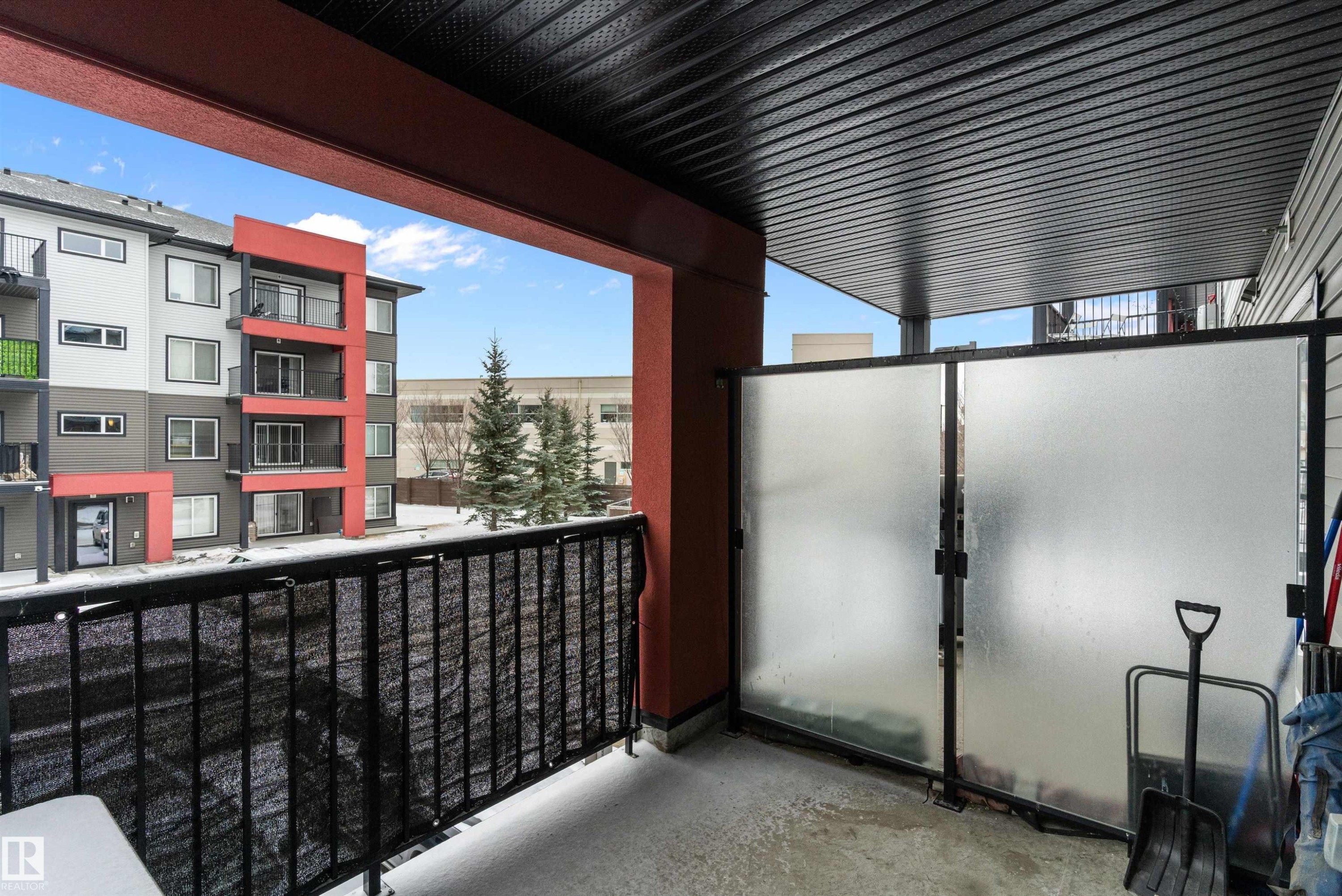 Expansive covered balcony featuring a black metal railing and frosted privacy panels - 231 344 Windermere Road, Edmonton, AB - Outdoor With Balcony With Exterior