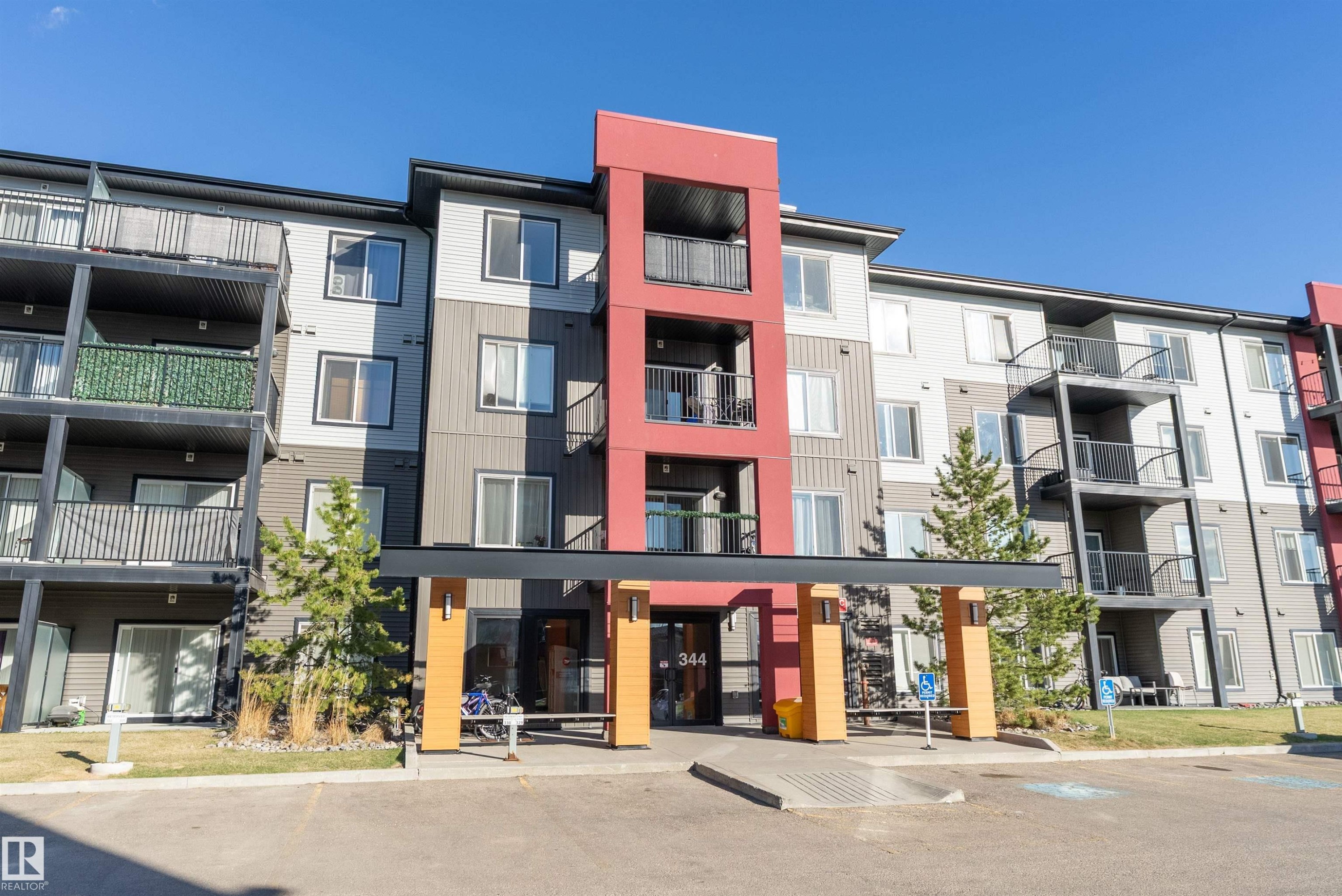 Multi-story residential building featuring a prominent red accent facade and multiple balconies - 231 344 Windermere Road, Edmonton, AB - Outdoor With Balcony With Facade