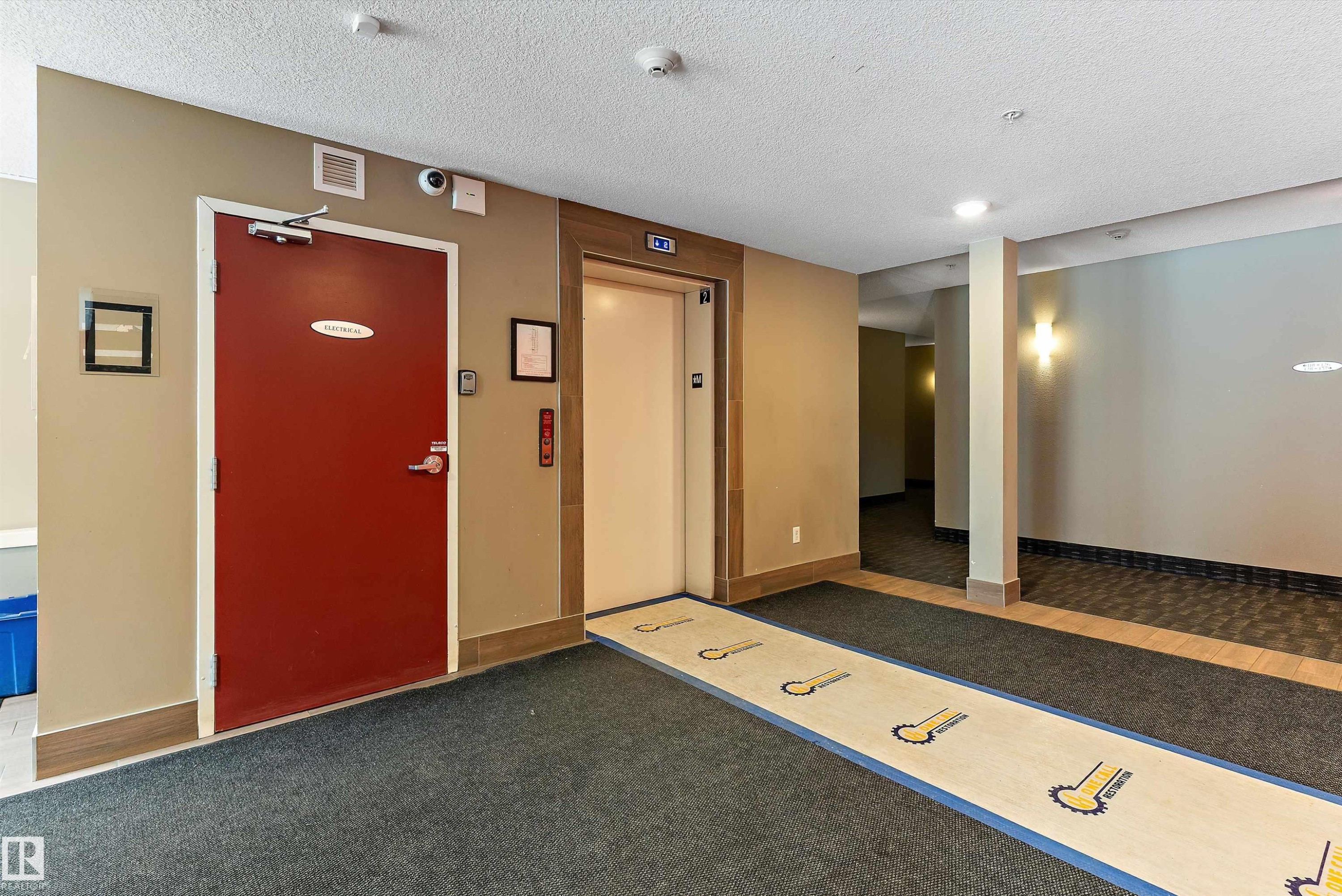 Building common area featuring an elevator, recessed lighting, and a red fire door - 231 344 Windermere Road, Edmonton, AB - Indoor Photo Showing Other Room