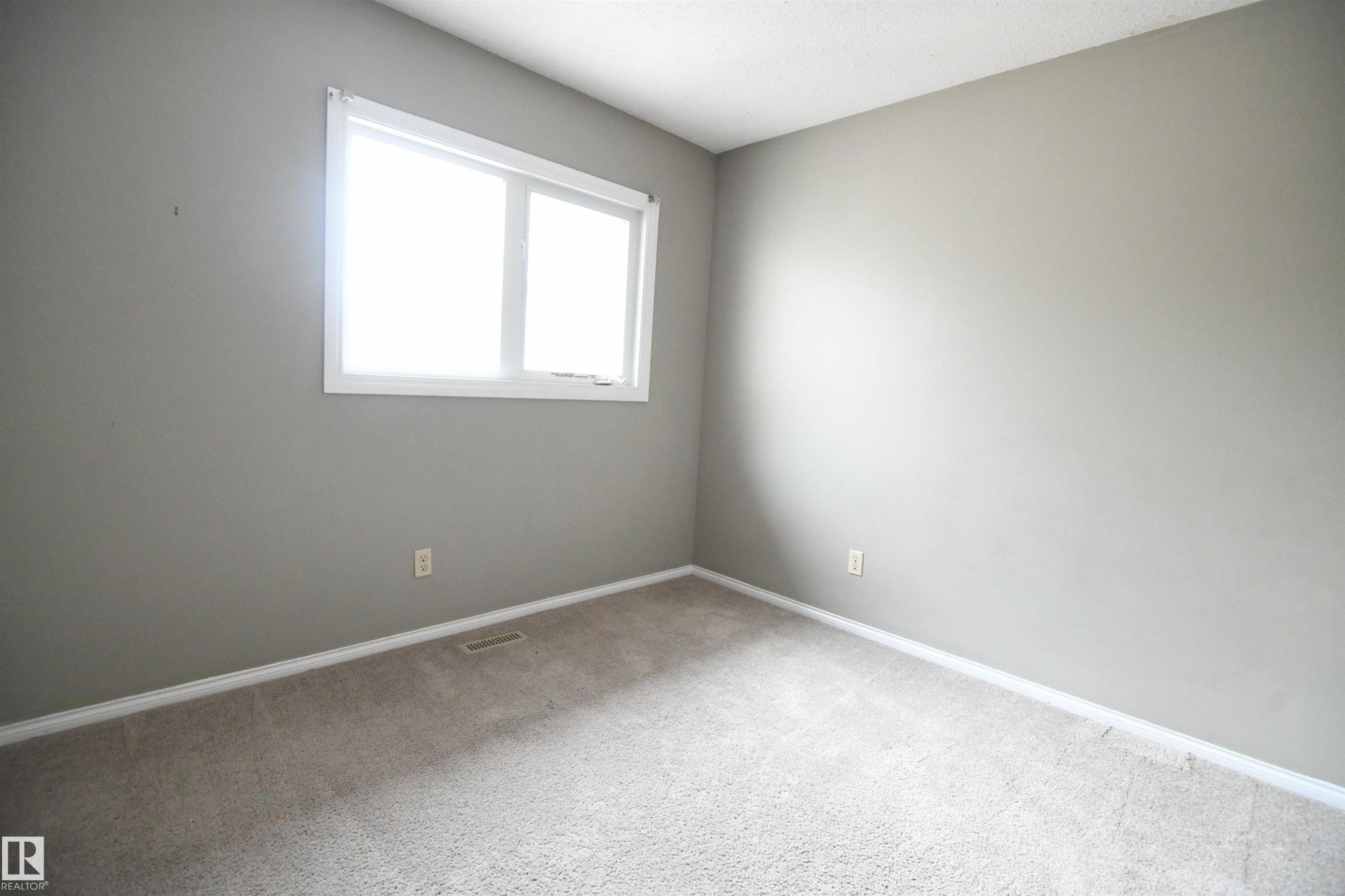 Both the second and third bedrooms are nicely sized, with generous closets. This one is at the rear of the of the unit, above the kitchen, and looks out over the rear yard and deck - 6706 36A Avenue, Edmonton, AB - Indoor Photo Showing Other Room