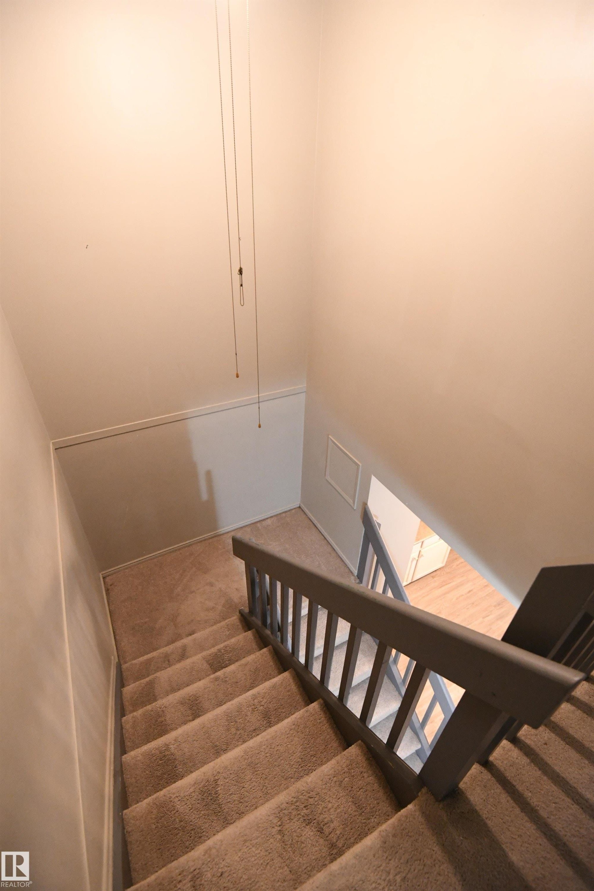 The tall ceiling, open railing staircase leads to and from the main floor family spaces - 6706 36A Avenue, Edmonton, AB - Indoor Photo Showing Other Room