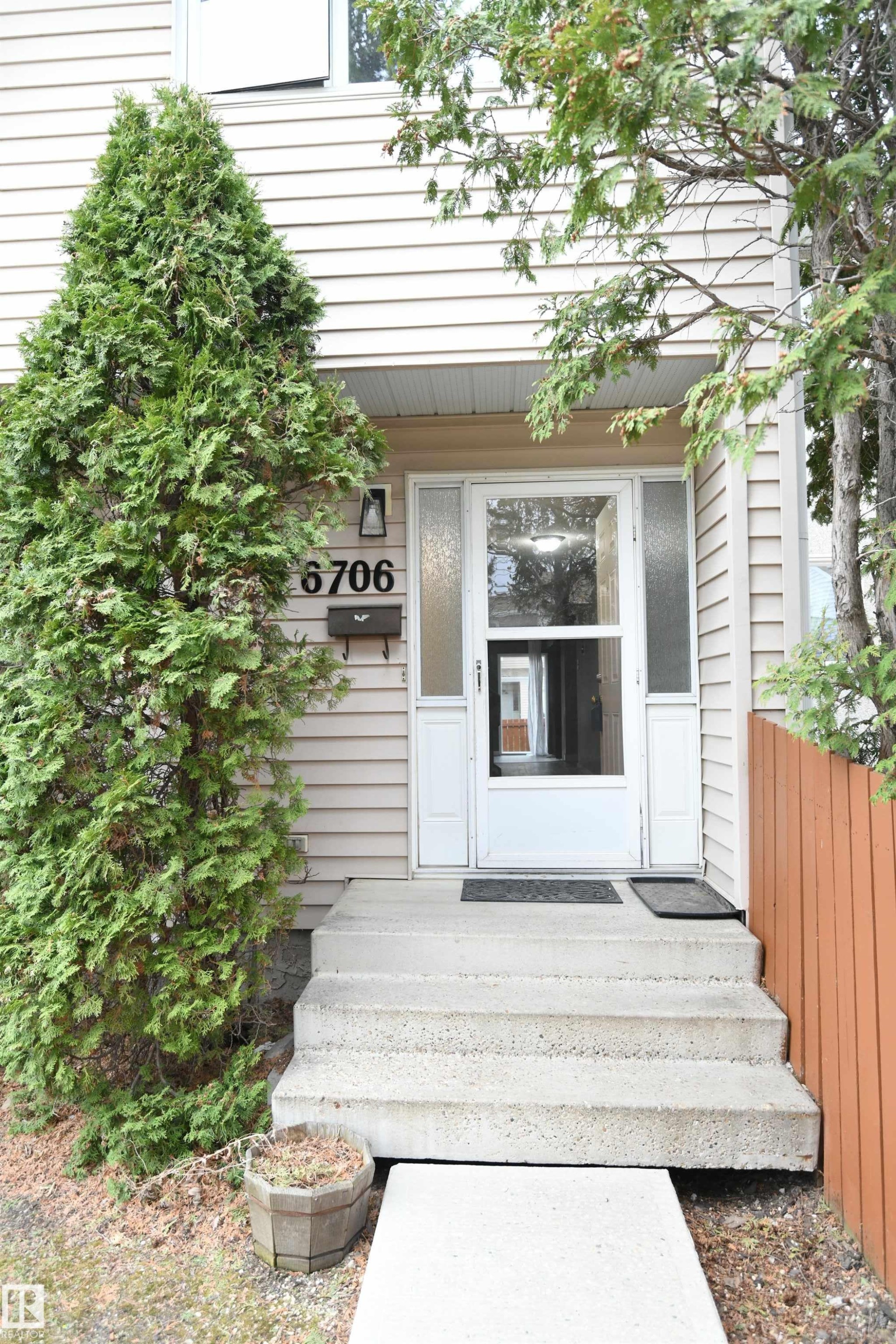The private front entrance is nicely treed, and is only a few steps away from the assigned parking stall for the unit. Additional street parking is conveniently also located just beyond that - 6706 36A Avenue, Edmonton, AB - Outdoor