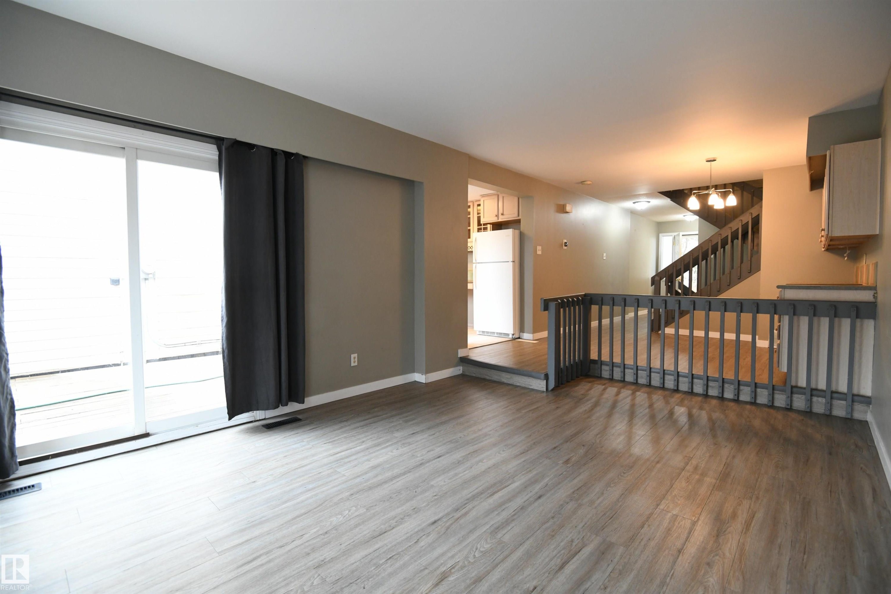 The open layout really does provide some great options for furniture placement, and makes for a great family and entertaining space. The patio doors open on to the private rear deck and yard - 6706 36A Avenue, Edmonton, AB - Indoor Photo Showing Other Room