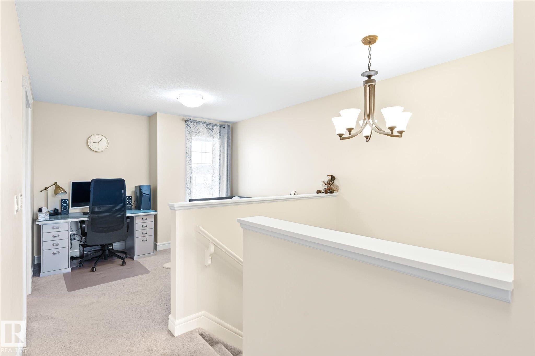 Second-story landing featuring a neutral color palette, an overhead chandelier, and a dedicated office nook with a window - 6864 Evans Wynd, Edmonton, AB - Indoor Photo Showing Other Room