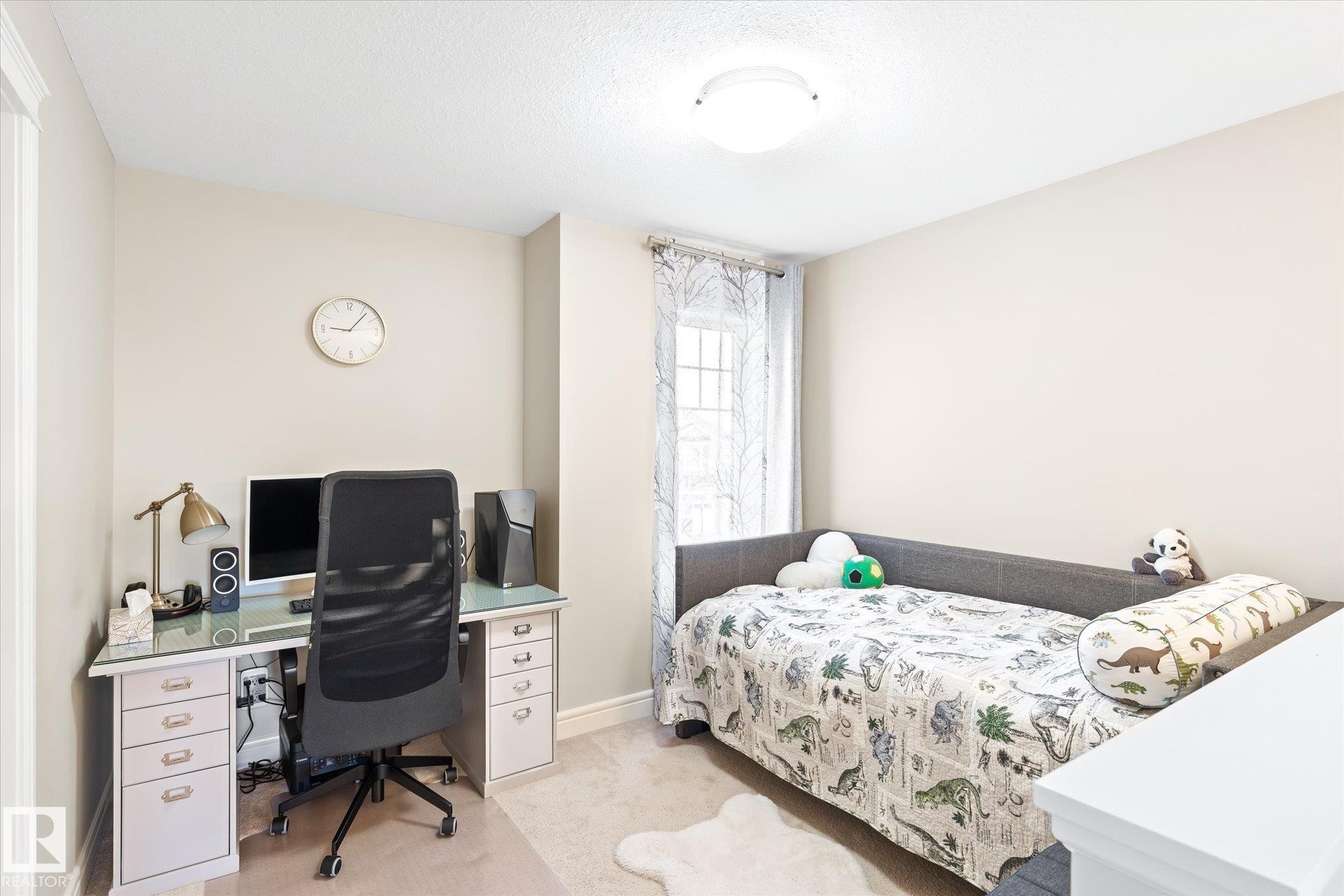 Neutral-toned room featuring light beige wall paint, a single window with decorative curtains, and light-colored carpeting - 6864 Evans Wynd, Edmonton, AB - Indoor Photo Showing Other Room