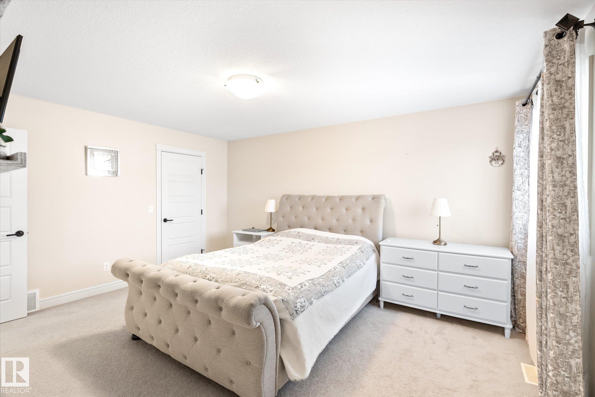 Neutral wall tones complement plush carpet flooring - 6864 Evans Wynd, Edmonton, AB - Indoor Photo Showing Bedroom