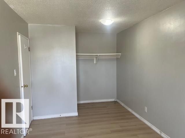 Interior room with wood-finish flooring, light gray wall paint, and white baseboards - 6117 120 Avenue, Edmonton, AB - Indoor
