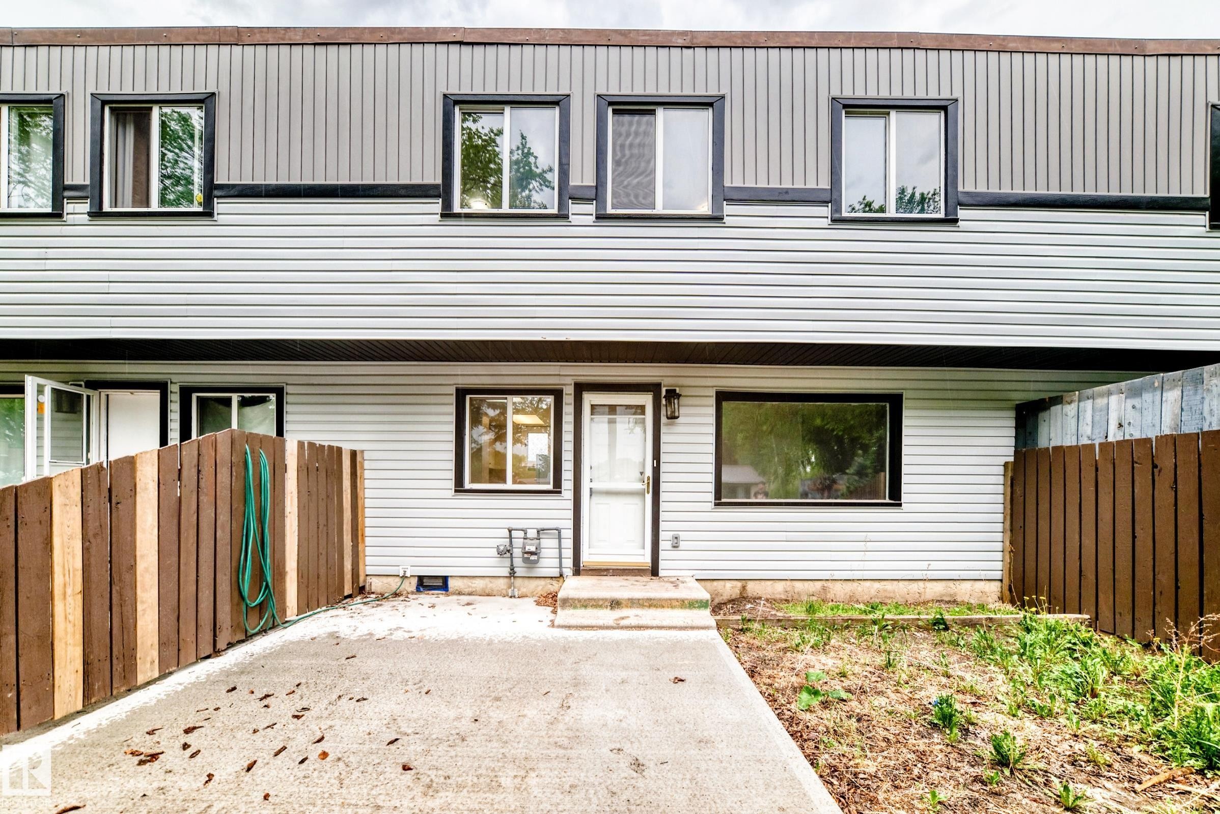 Two-story facade with light-colored horizontal siding and dark trim accents - 6117 120 Avenue, Edmonton, AB - Outdoor With Exterior