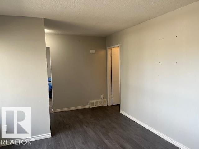 Interior space featuring wood-finish flooring, light grey painted walls, white baseboards, and a white ceiling - 6117 120 Avenue, Edmonton, AB - Indoor Photo Showing Other Room