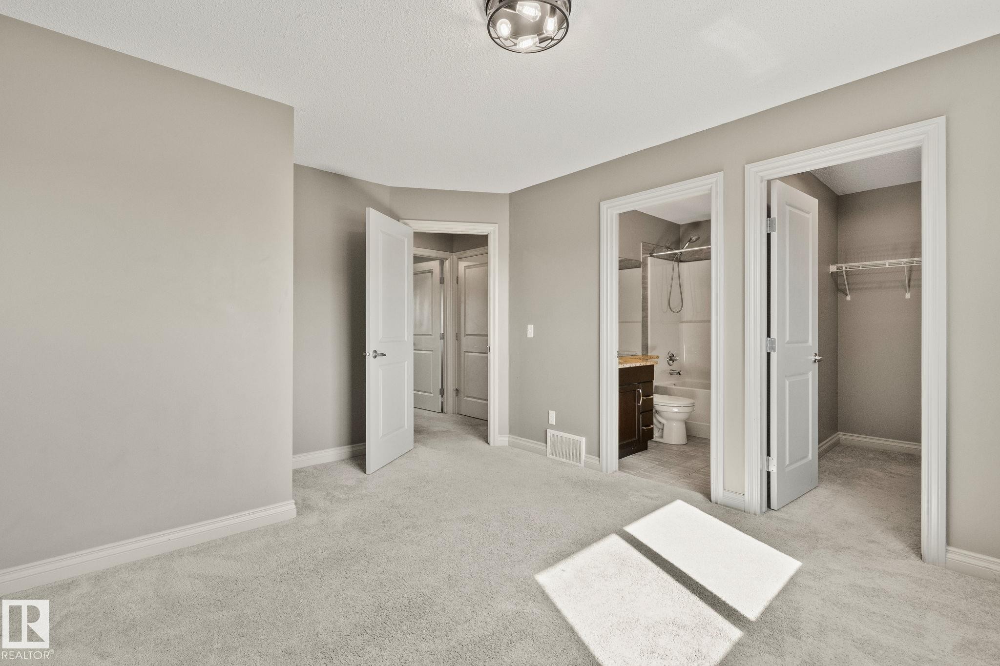 Carpeted bedroom with neutral wall tones, a semi-flush mount ceiling light, and white trim - 46 445 Brintnell Boulevard, Edmonton, AB - Indoor Photo Showing Other Room
