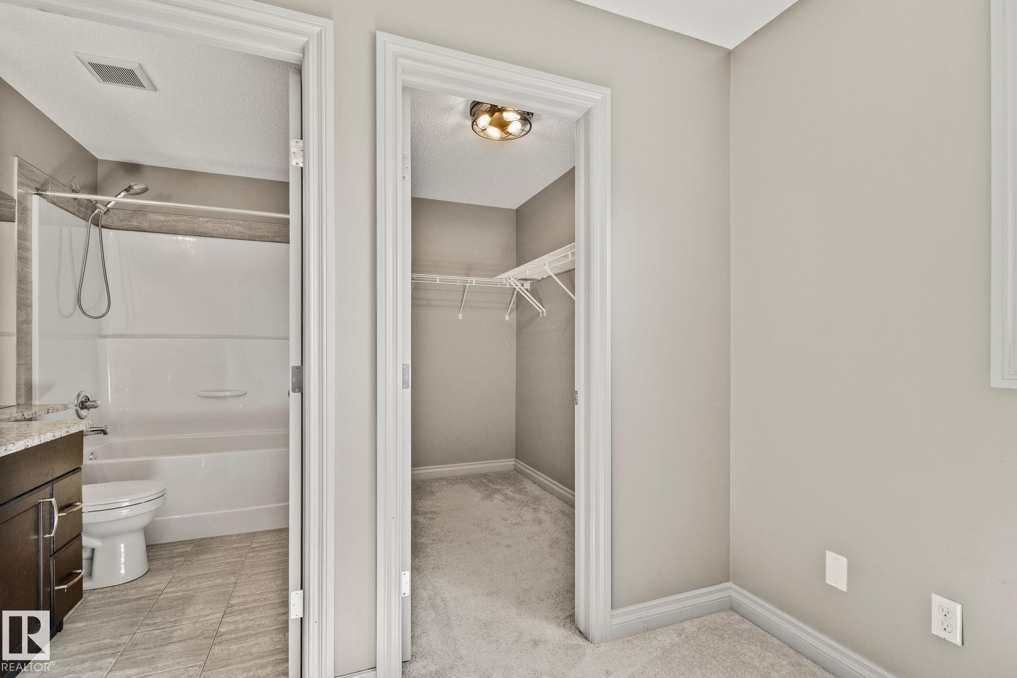 Walk-in closet with carpet flooring and overhead lighting - 46 445 Brintnell Boulevard, Edmonton, AB - Indoor Photo Showing Bathroom