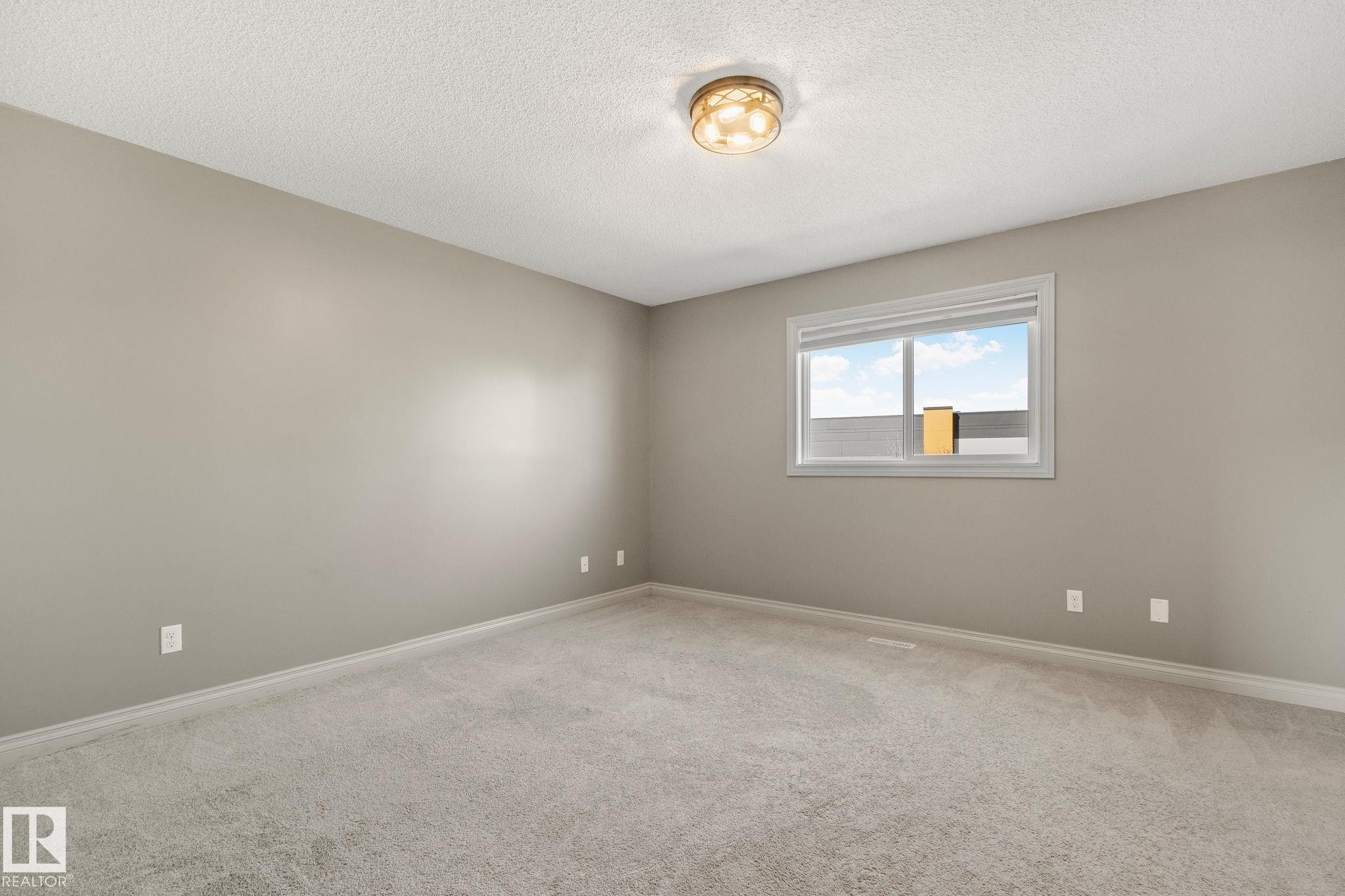 Spacious room featuring neutral carpeting, light-toned wall paint, and white trim - 46 445 Brintnell Boulevard, Edmonton, AB - Indoor Photo Showing Other Room