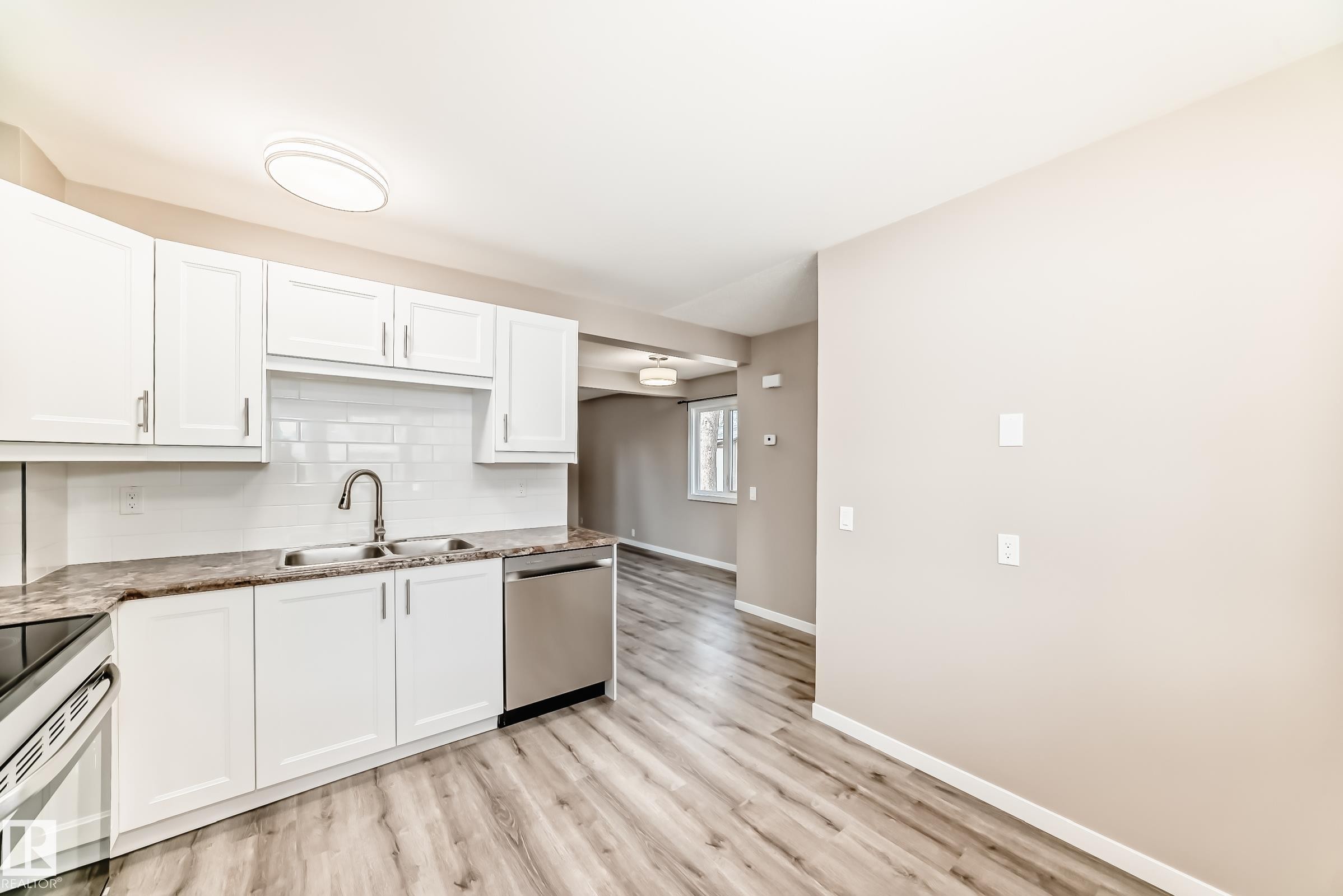 Kitchen featuring white cabinetry, subway tile backsplash, and stainless steel dishwasher - 2578 138A Avenue, Edmonton, AB - Indoor Photo Showing Kitchen With Double Sink