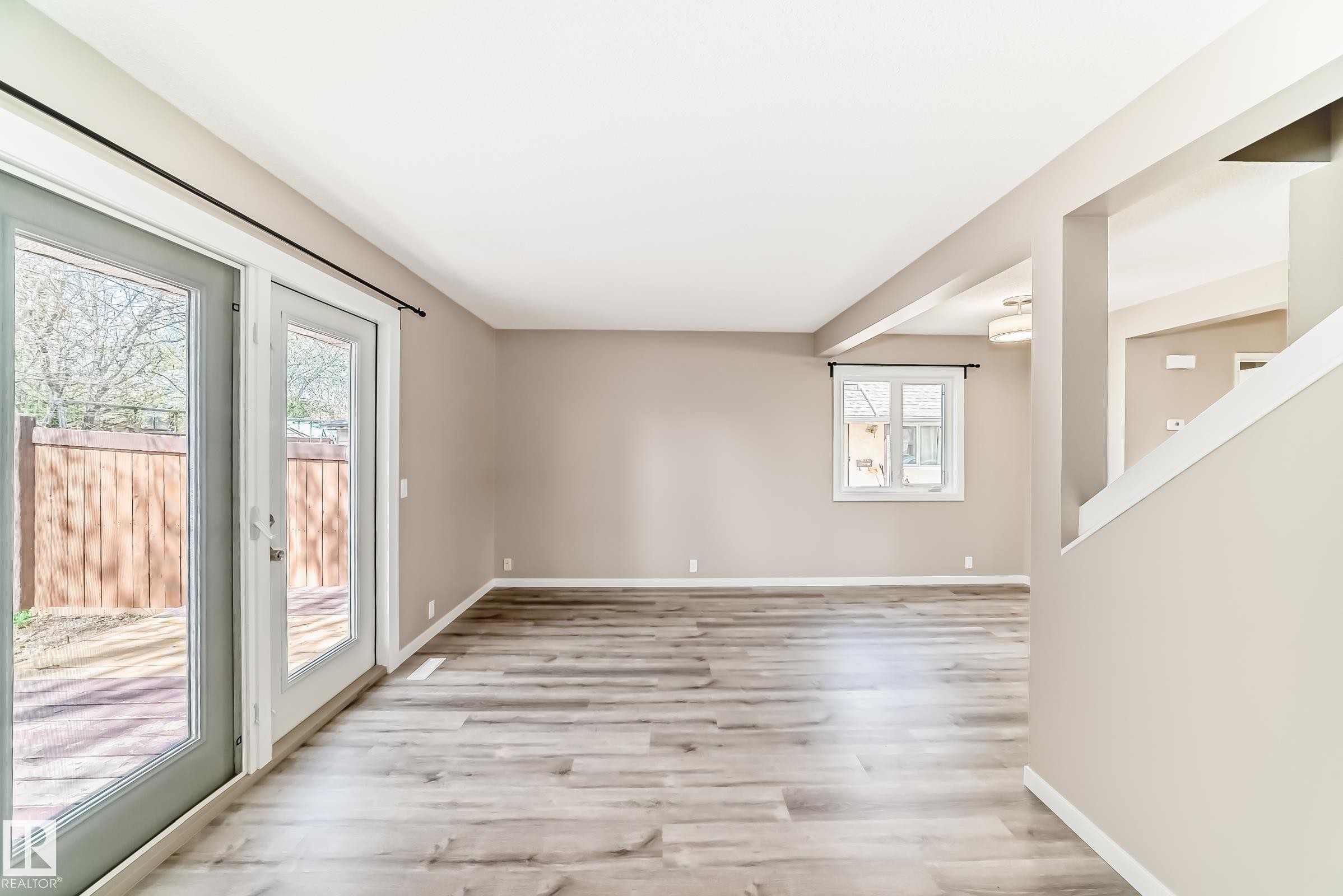 Spacious living area featuring wood-finish flooring, neutral wall tones, and white trim - 2578 138A Avenue, Edmonton, AB - Indoor Photo Showing Other Room