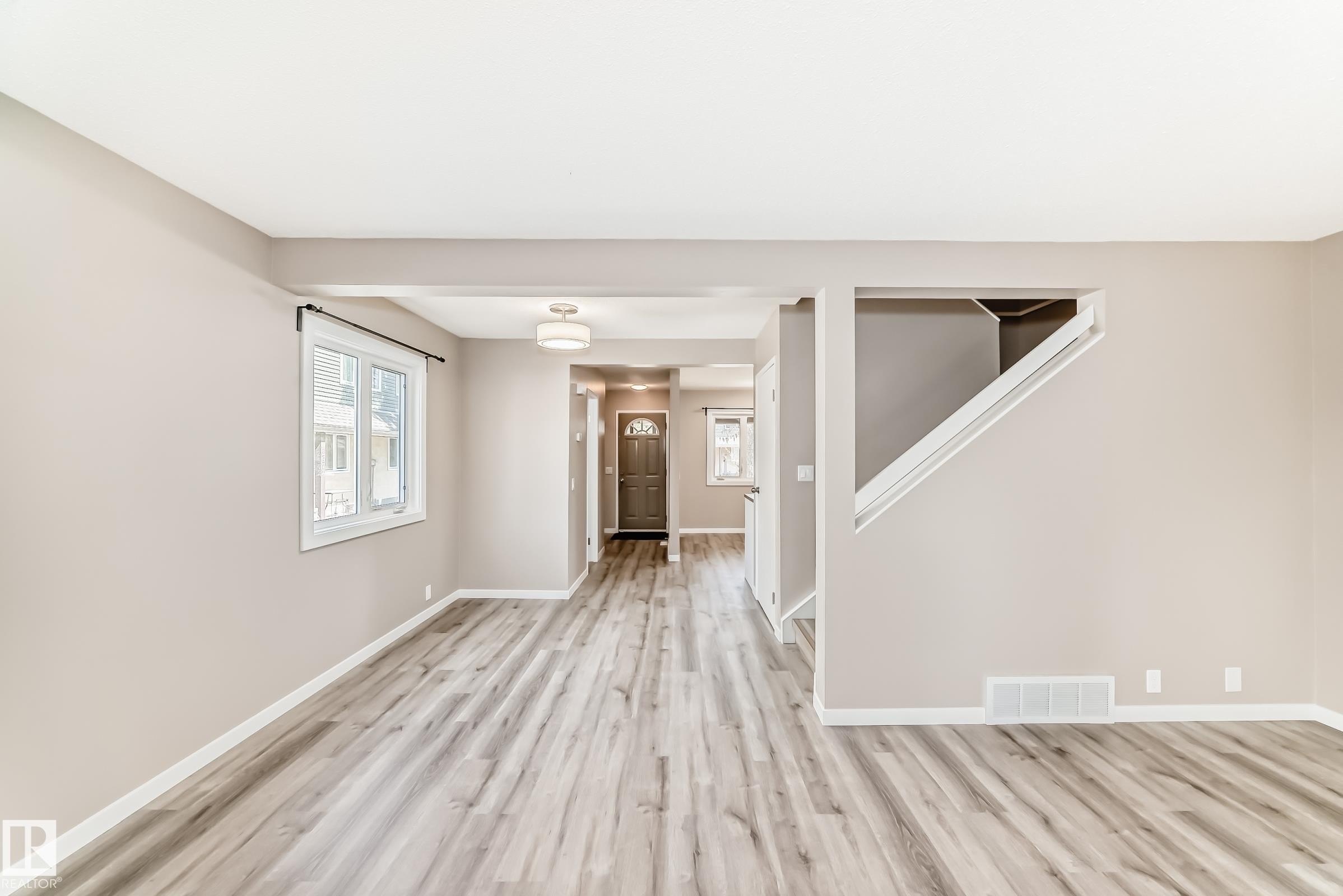 Spacious interior featuring wide plank wood-finish flooring, neutral wall tones, and white trim - 2578 138A Avenue, Edmonton, AB - Indoor Photo Showing Other Room