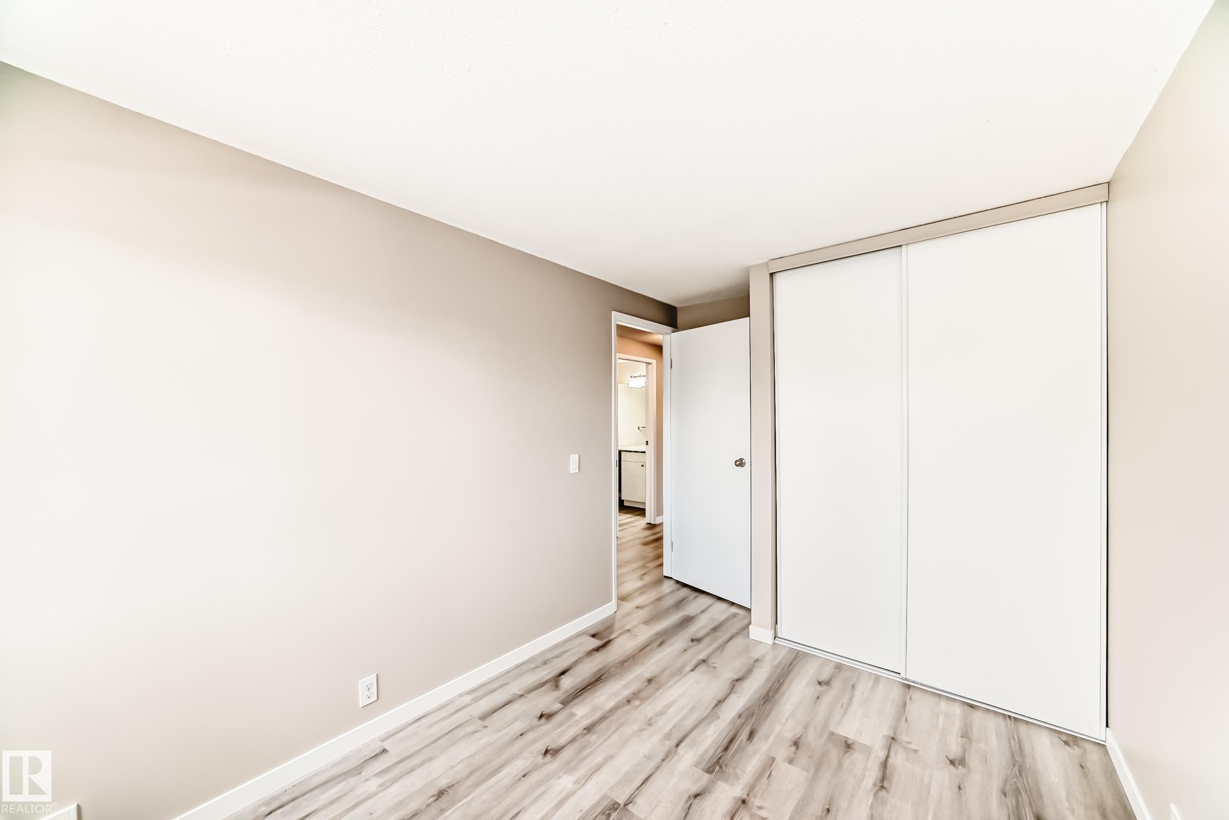 Room featuring wood-finish flooring, neutral wall tones, and white baseboards - 2578 138A Avenue, Edmonton, AB - Indoor Photo Showing Other Room