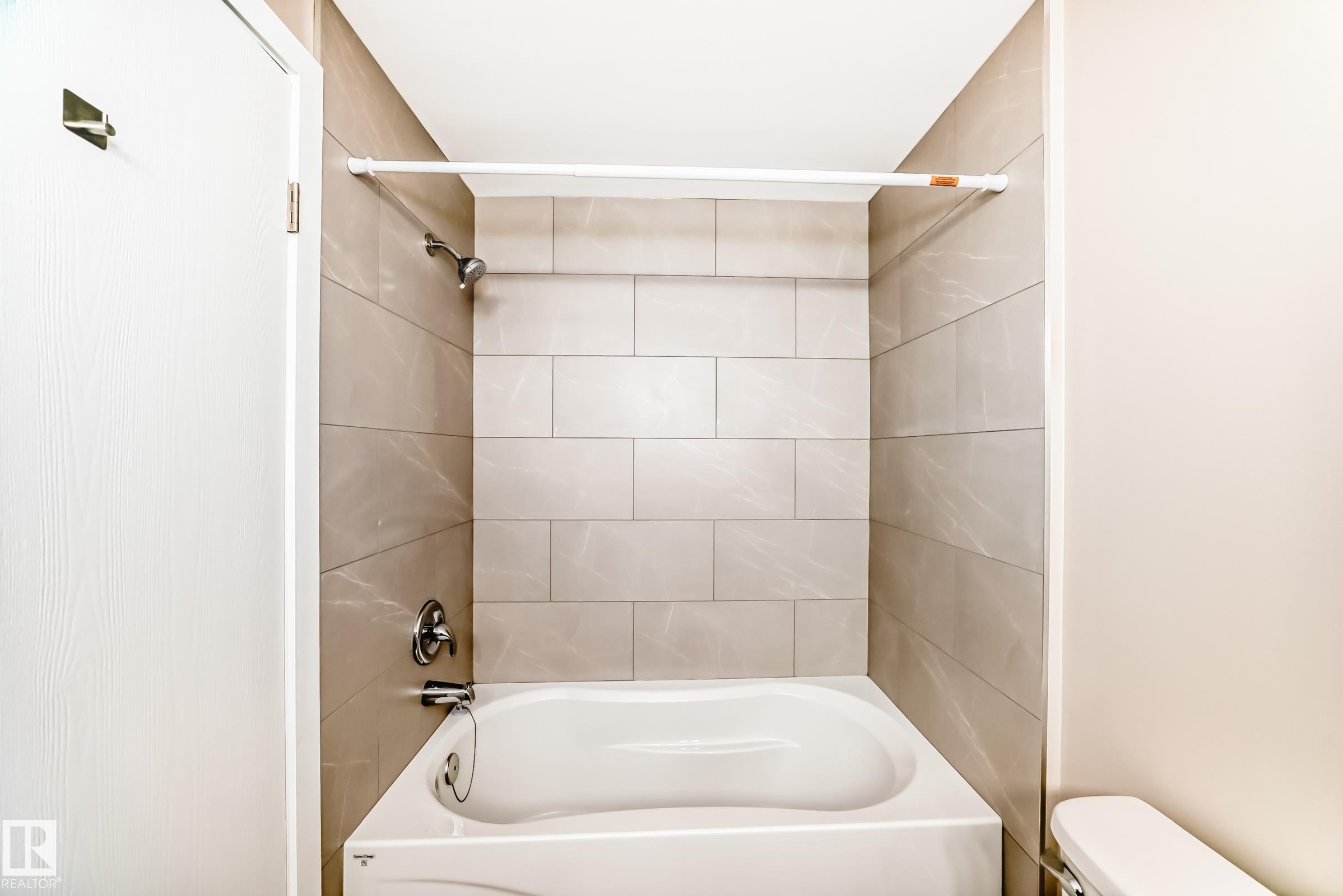Bathtub with subway tile surround, chrome fixtures, and a white shower rod - 2578 138A Avenue, Edmonton, AB - Indoor Photo Showing Bathroom