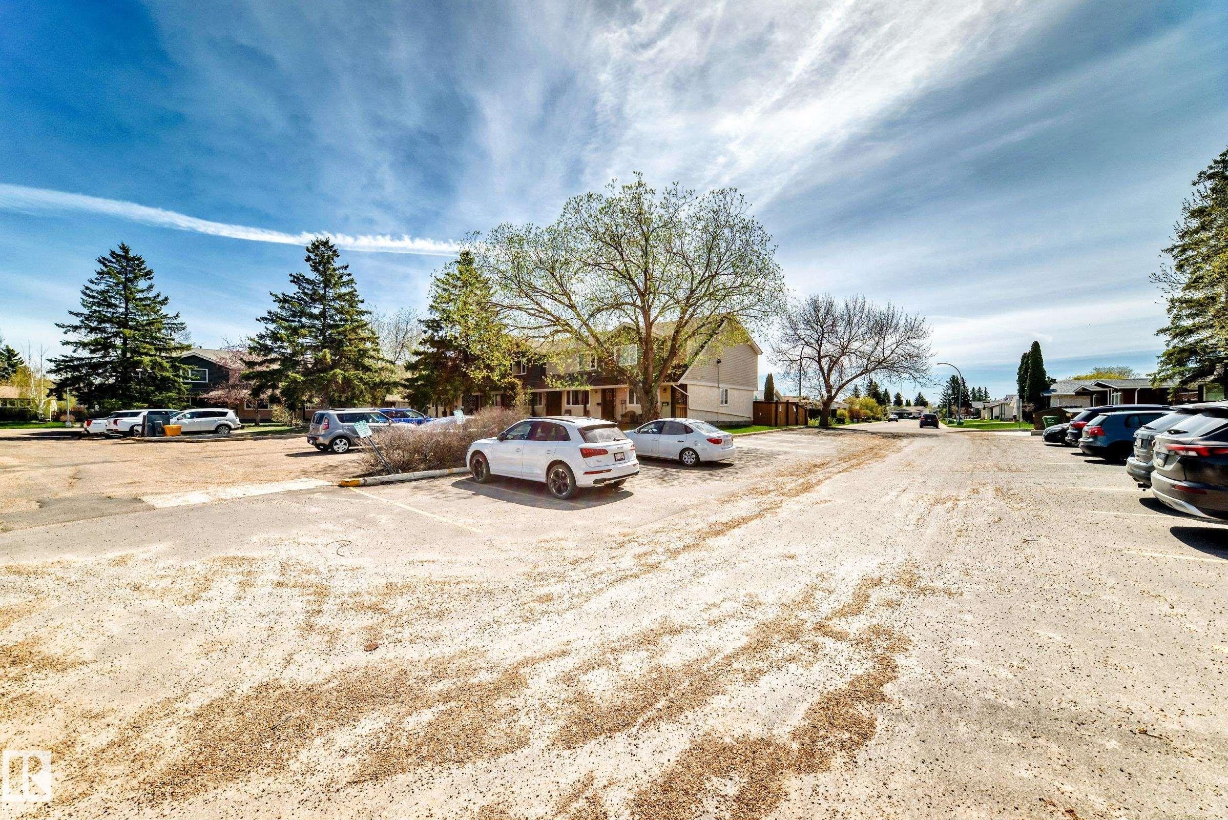 Expansive gravel parking area with mature trees and surrounding residential structures - 2578 138A Avenue, Edmonton, AB - Outdoor