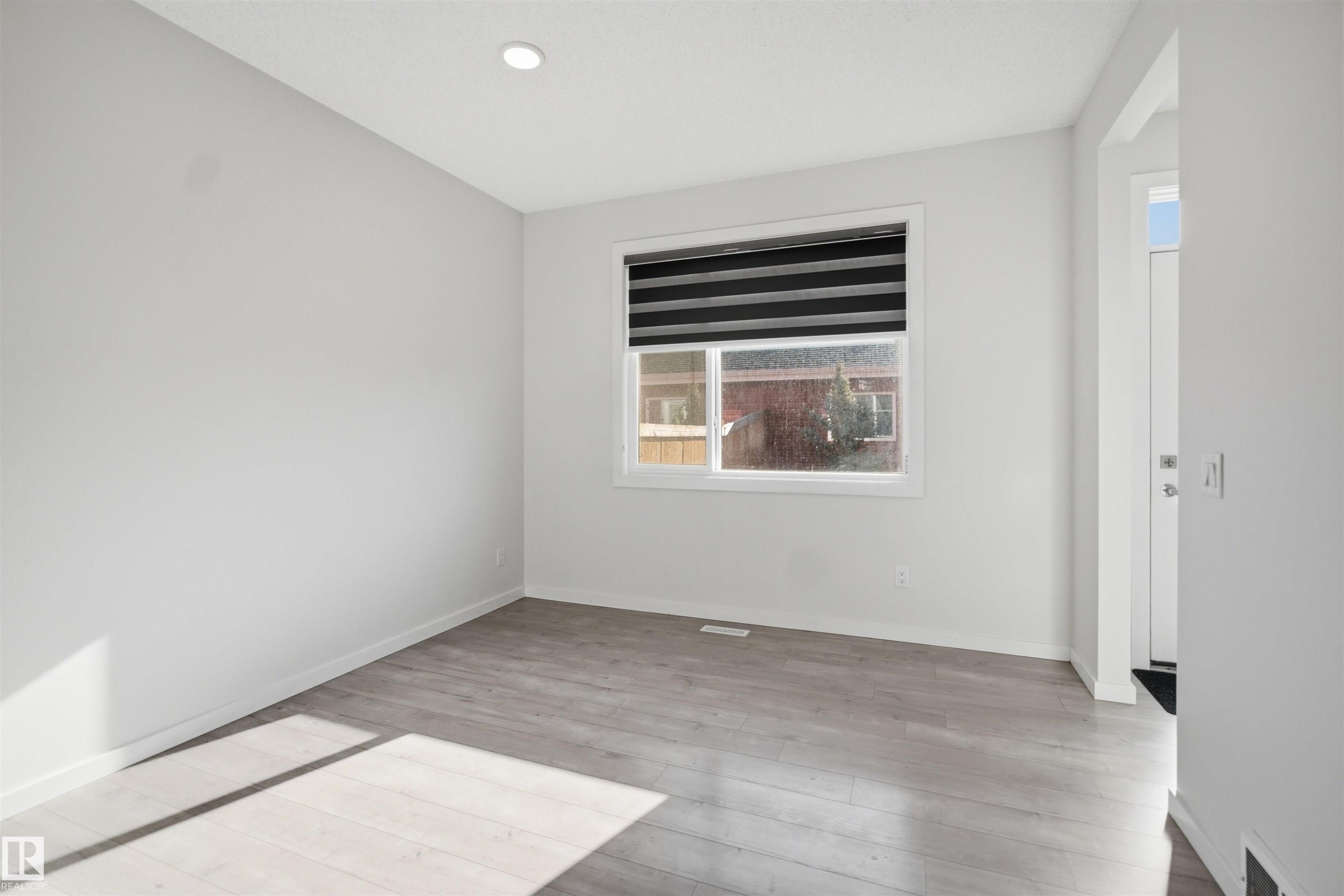This bright room features light-colored flooring, a window with horizontal blinds, and a recessed ceiling light - 2125 Maple Road Nw, Edmonton, AB - Indoor Photo Showing Other Room