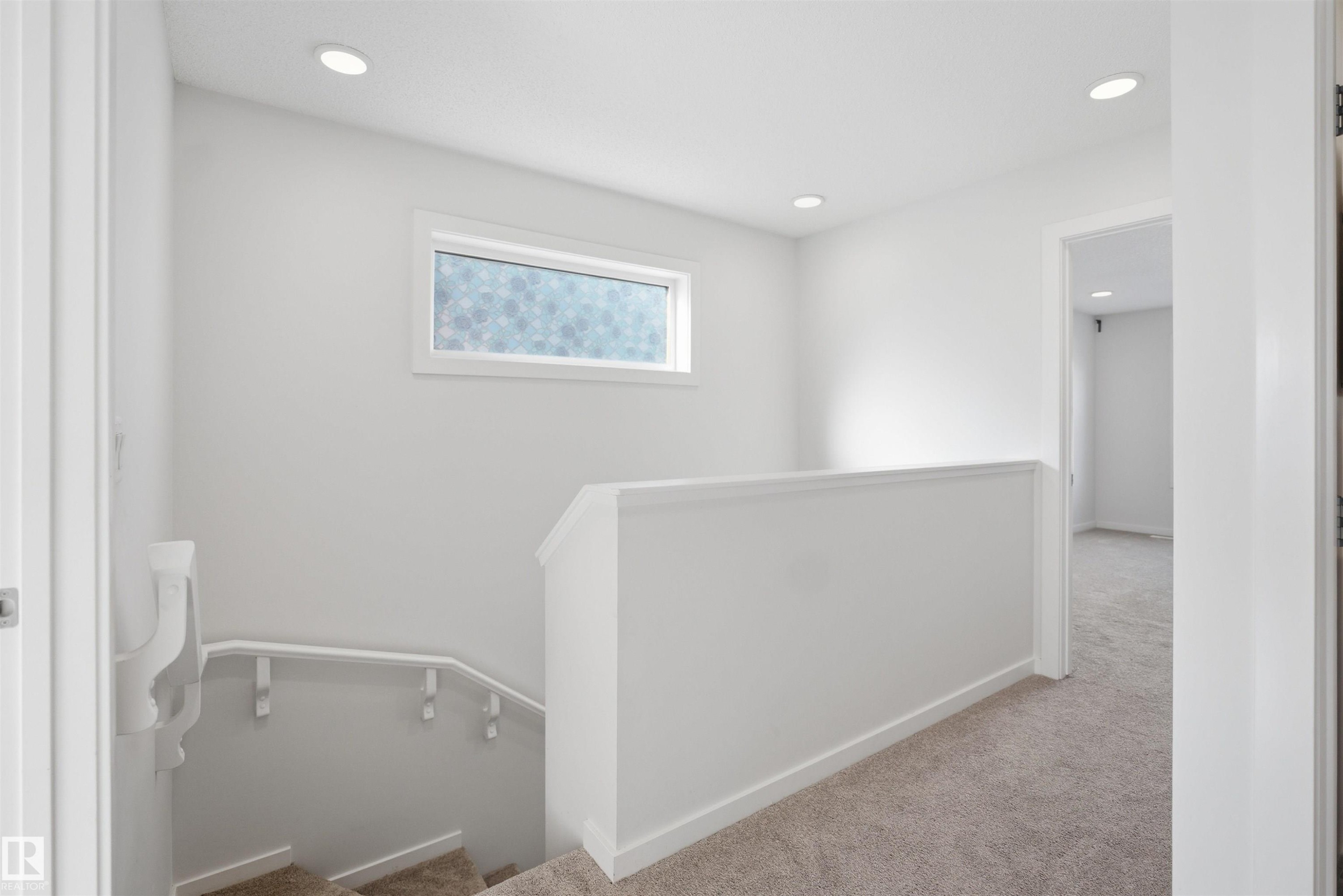 Bright hallway with recessed lighting, a patterned window, white walls, and carpeted flooring - 2125 Maple Road Nw, Edmonton, AB - Indoor