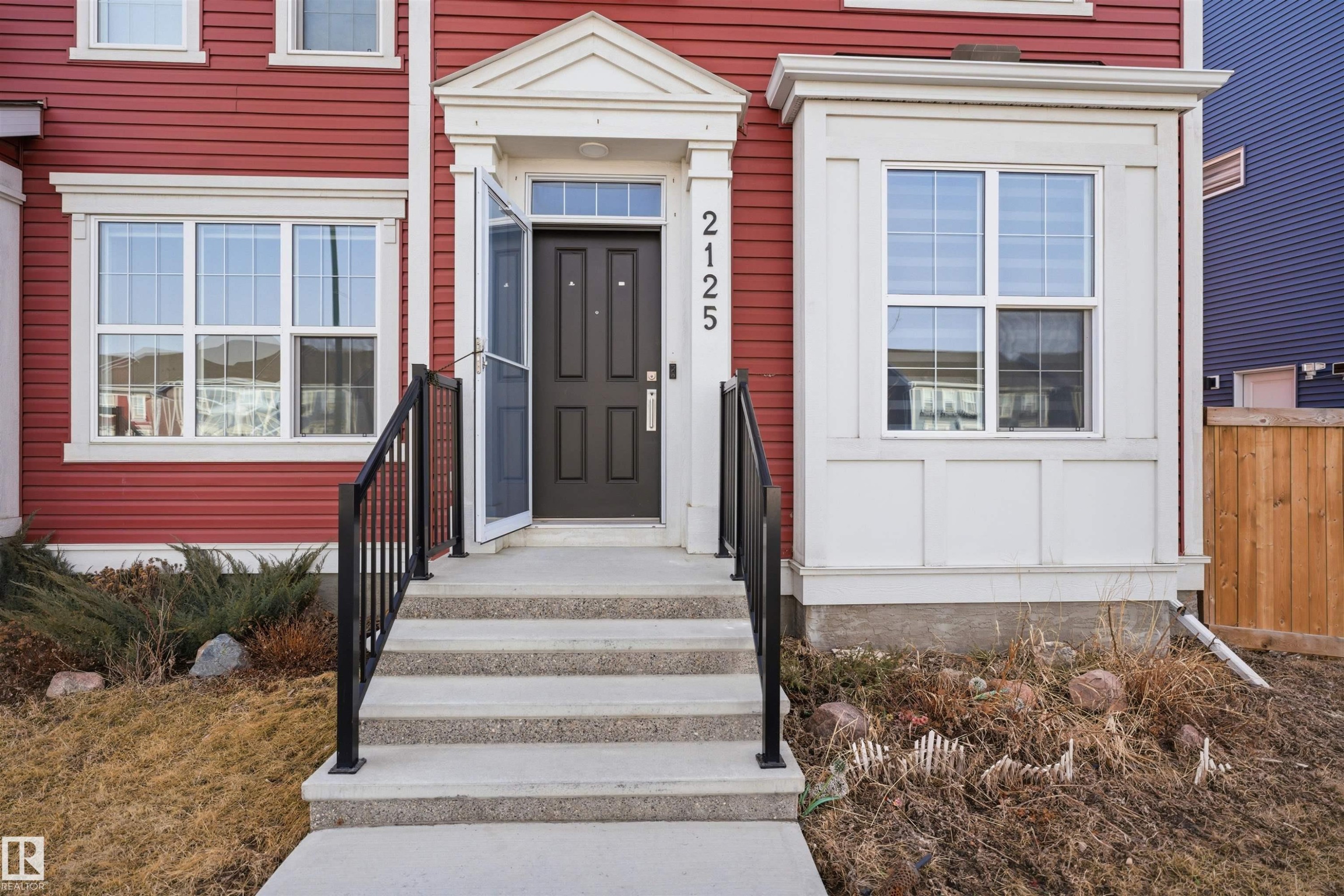 The property features a bold red exterior with white trim around the windows and main entrance - 2125 Maple Road Nw, Edmonton, AB - Outdoor