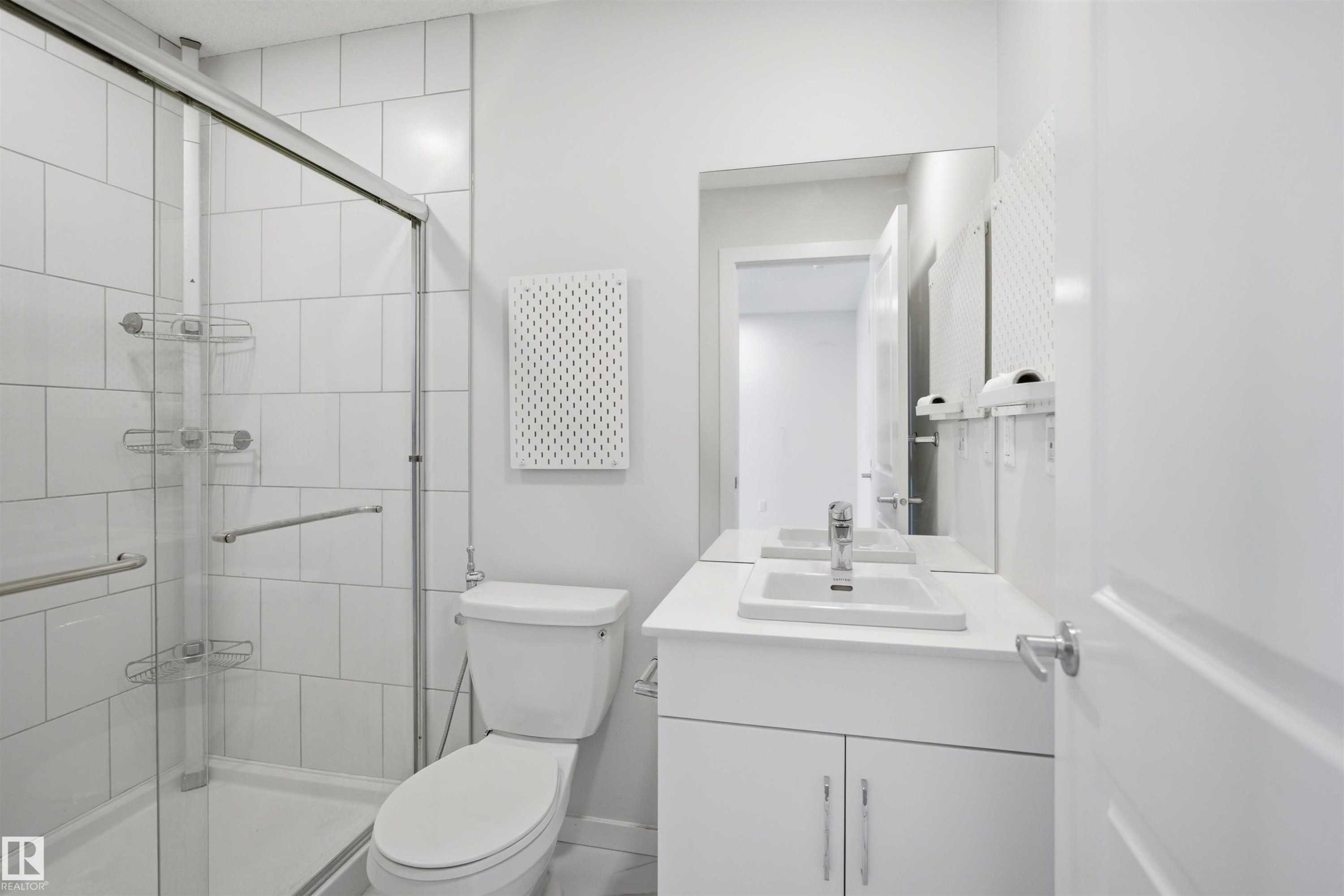 Bathroom featuring a glass-enclosed shower, a toilet, and a vanity with a sink and mirror - 2125 Maple Road Nw, Edmonton, AB - Indoor Photo Showing Bathroom