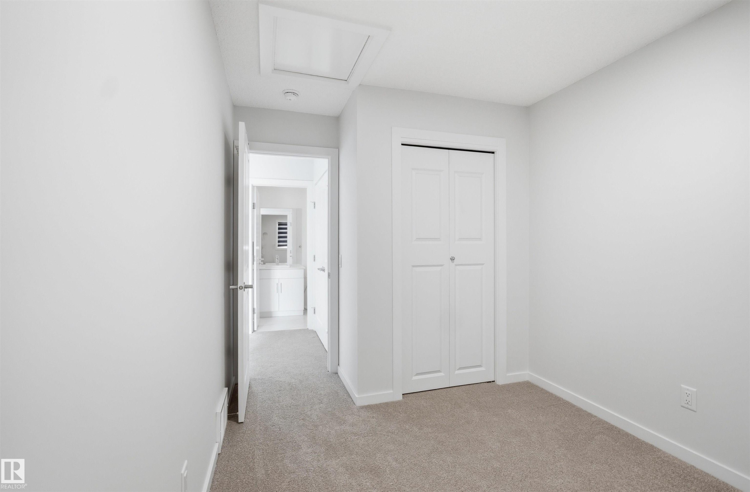Room featuring light gray walls, gray carpet, and a white bi-fold closet door - 2125 Maple Road Nw, Edmonton, AB - Indoor Photo Showing Other Room