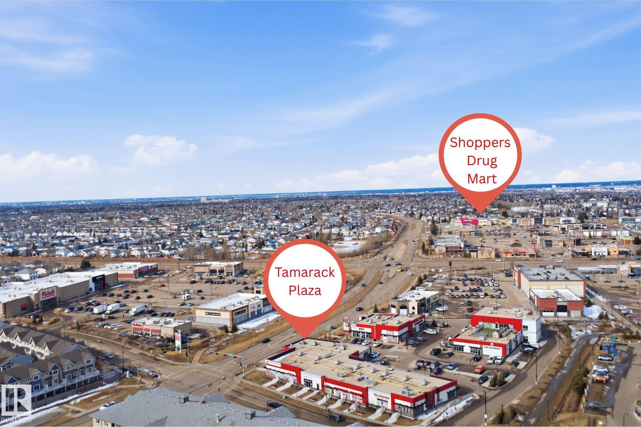 Aerial view showcasing the surrounding commercial areas including Tamarack Plaza and Shoppers Drug Mart, along with extensive residential areas - 2125 Maple Road Nw, Edmonton, AB - Outdoor With View