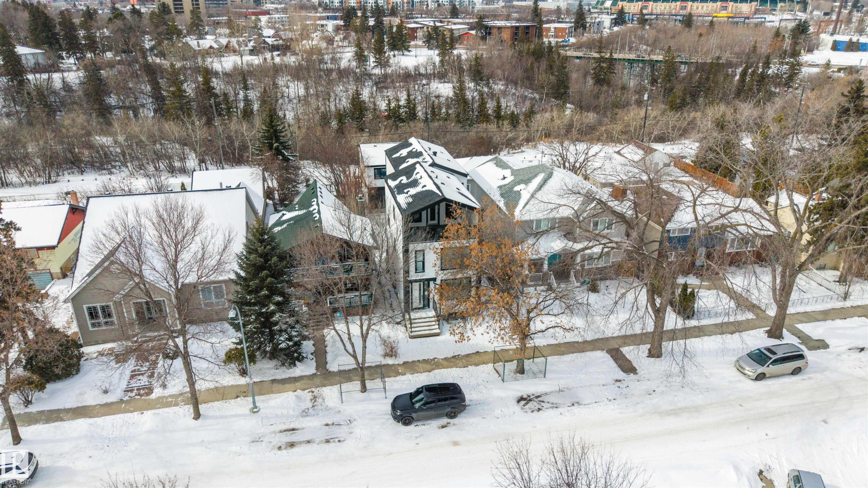 The property features a distinctive dark-colored exterior with white trim and a prominent peaked roofline - 7927 112S Avenue, Edmonton, AB - Outdoor