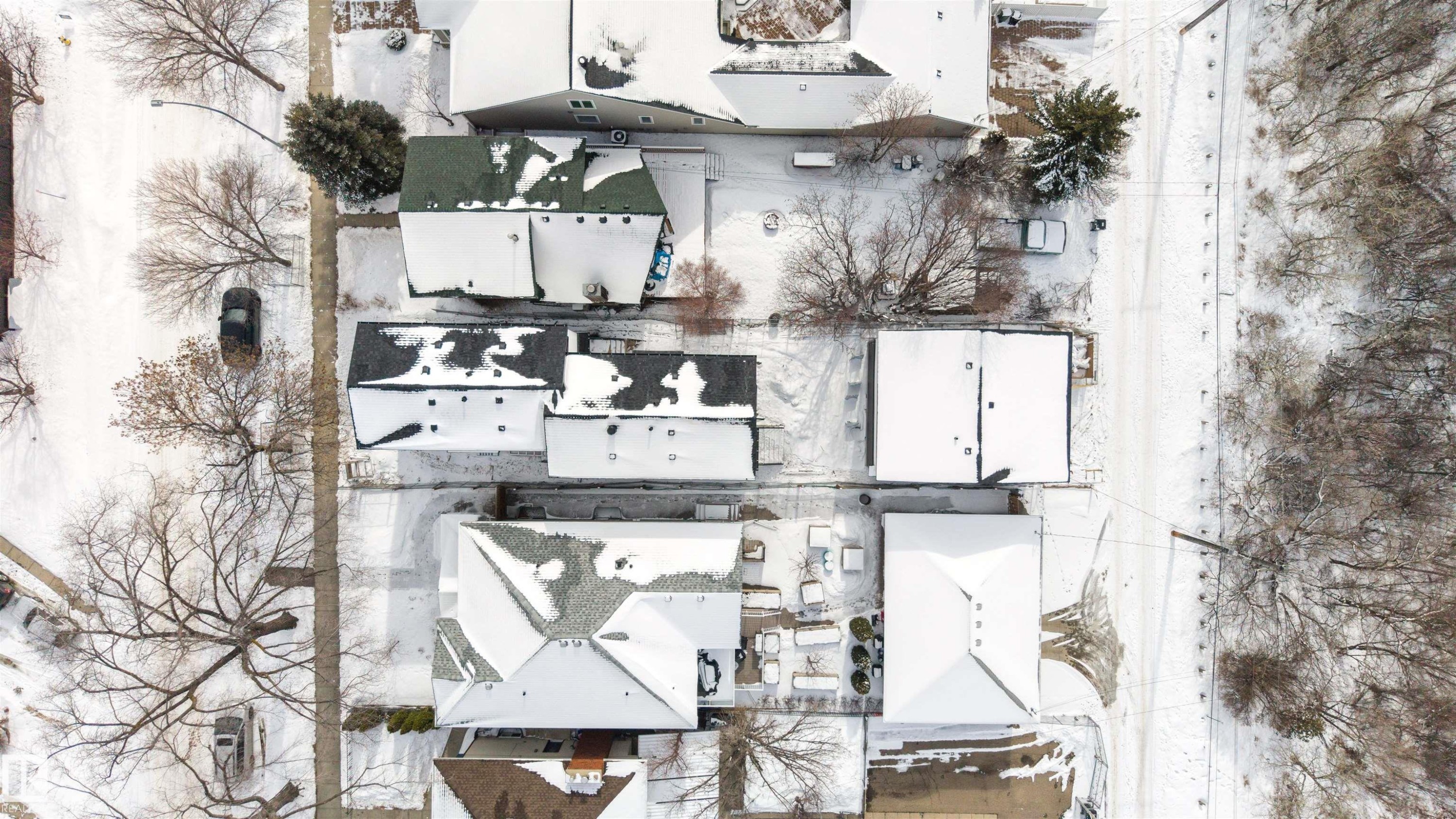 Aerial view of the neighborhood showcasing snow-covered rooftops and mature trees - 7927 112S Avenue, Edmonton, AB -