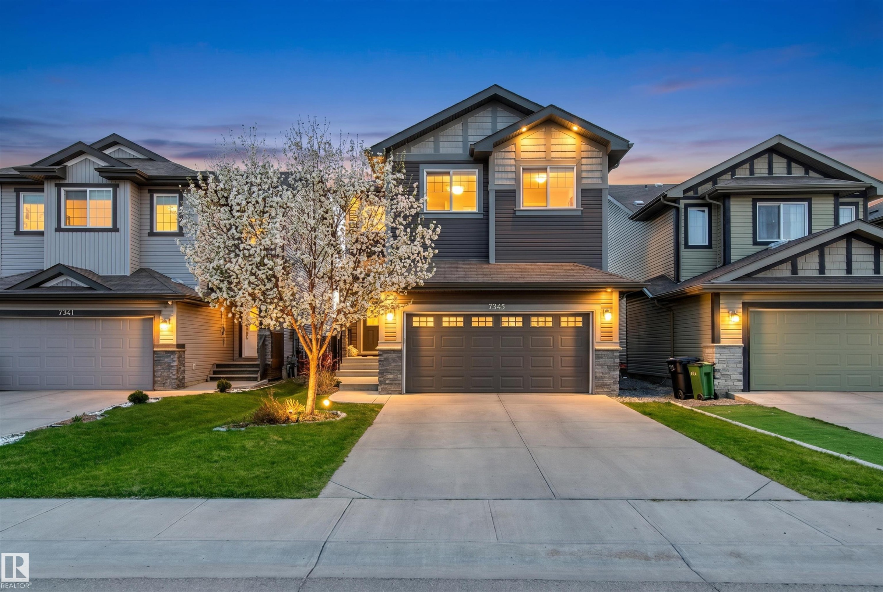 Two-story exterior featuring two-tone siding with brick accent, 2 car attached garage, and mature landscaping. - 7343 Armour Crescent, Edmonton, AB - Outdoor With Facade