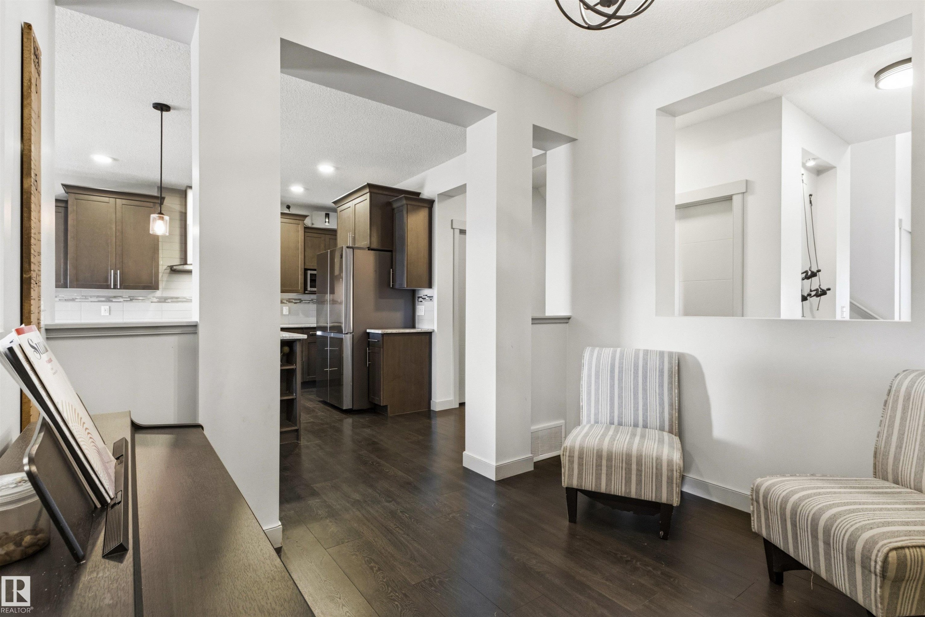 Open-concept interior featuring dark wood-finish flooring throughout - 7343 Armour Crescent, Edmonton, AB - Indoor Photo Showing Other Room
