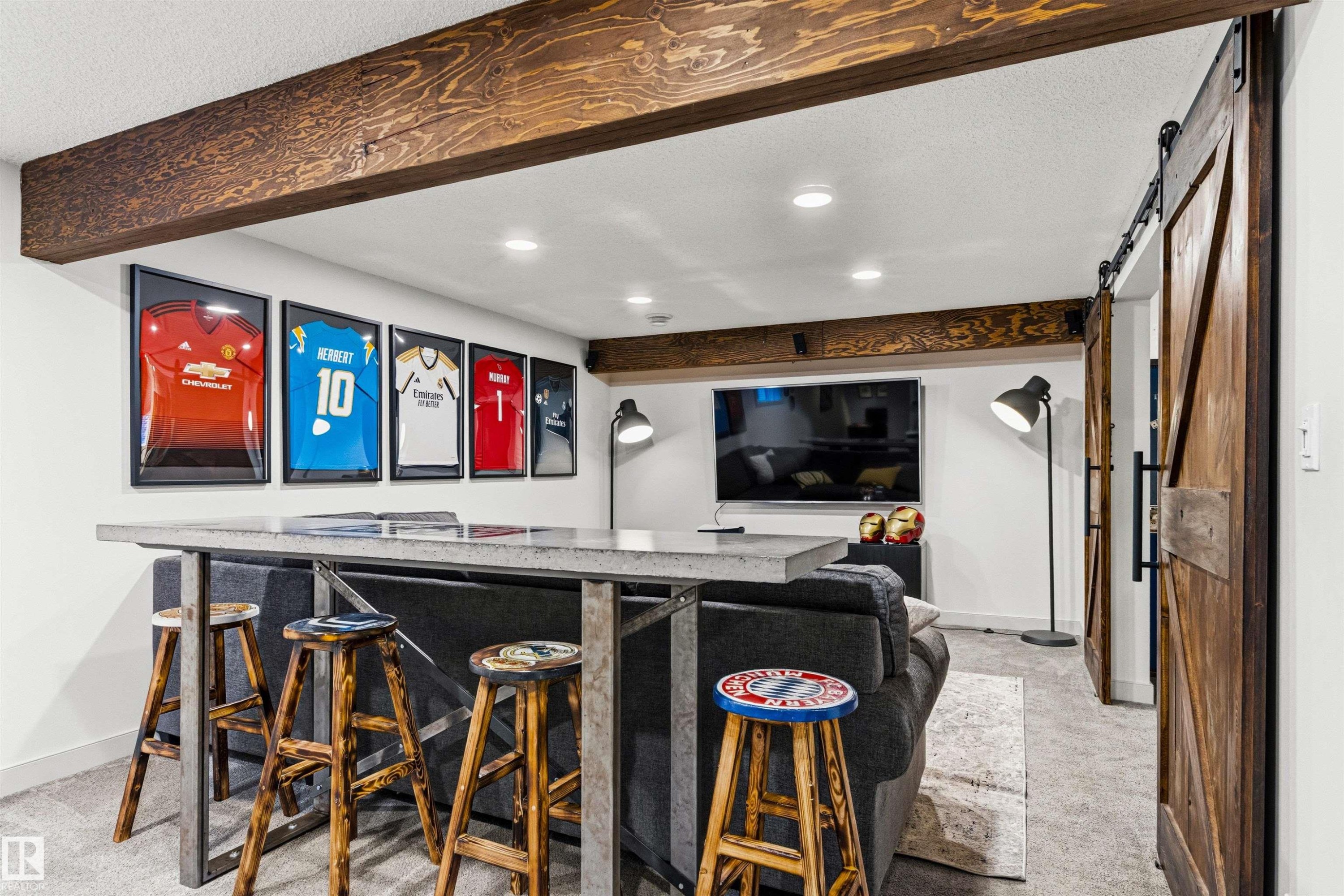 Recreation room featuring exposed wood beams, recessed lighting, and a barn door entry to bedroom. - 7343 Armour Crescent, Edmonton, AB - Indoor