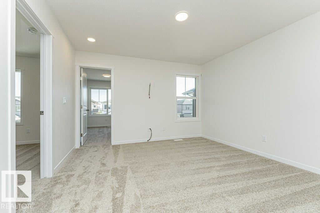 Carpeted room featuring white walls, a single window, and recessed lighting - 6271 180 Avenue Nw, Edmonton, AB