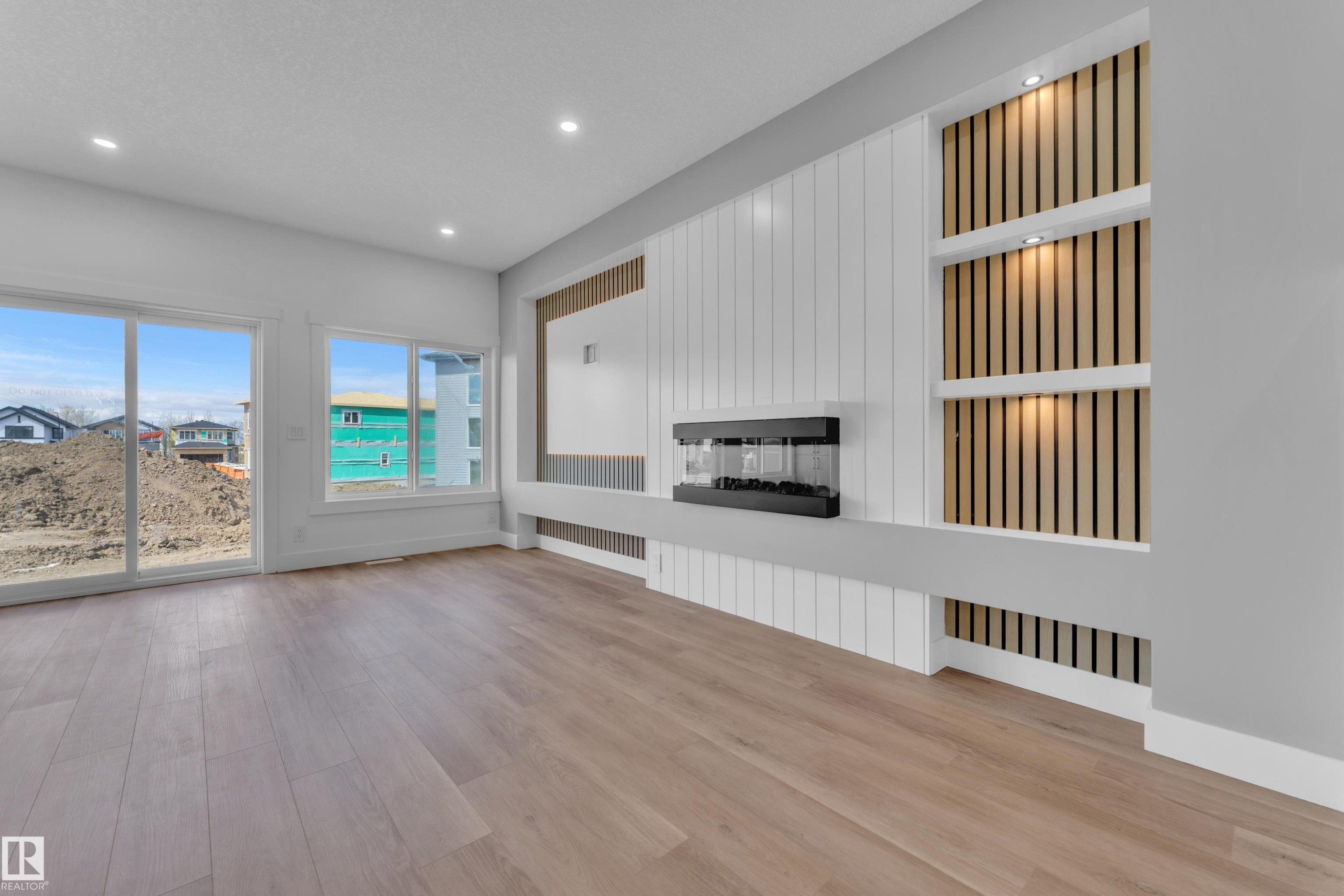 Spacious interior featuring wide plank wood-finish flooring and recessed lighting - 3116 8 Avenue, Edmonton, AB
