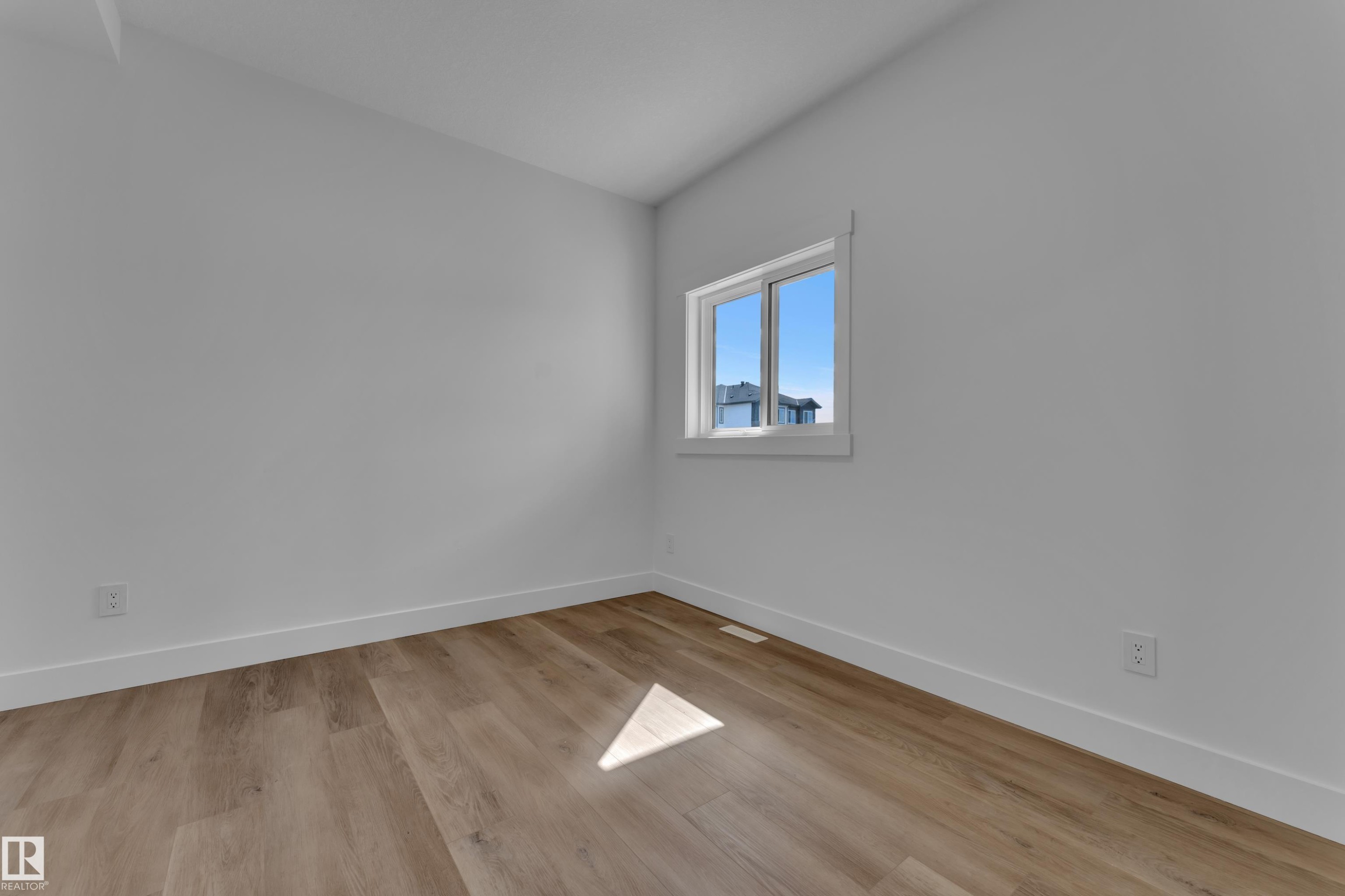 Room featuring wood-finish flooring, white baseboards, and a single window with white trim - 3116 8 Avenue, Edmonton, AB