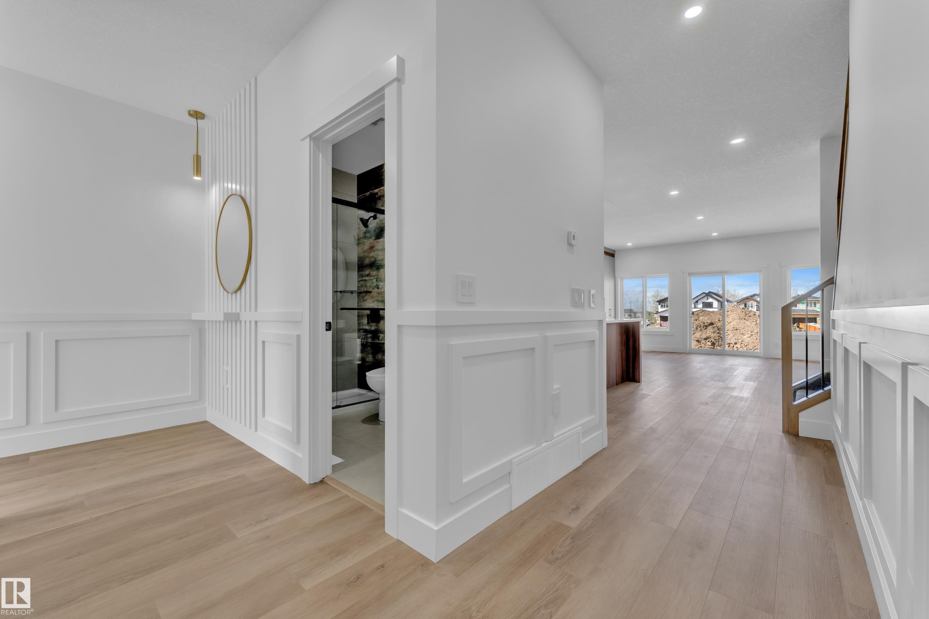 Bright entryway featuring wood-finish flooring, white wainscoting, and recessed lighting - 3116 8 Avenue, Edmonton, AB