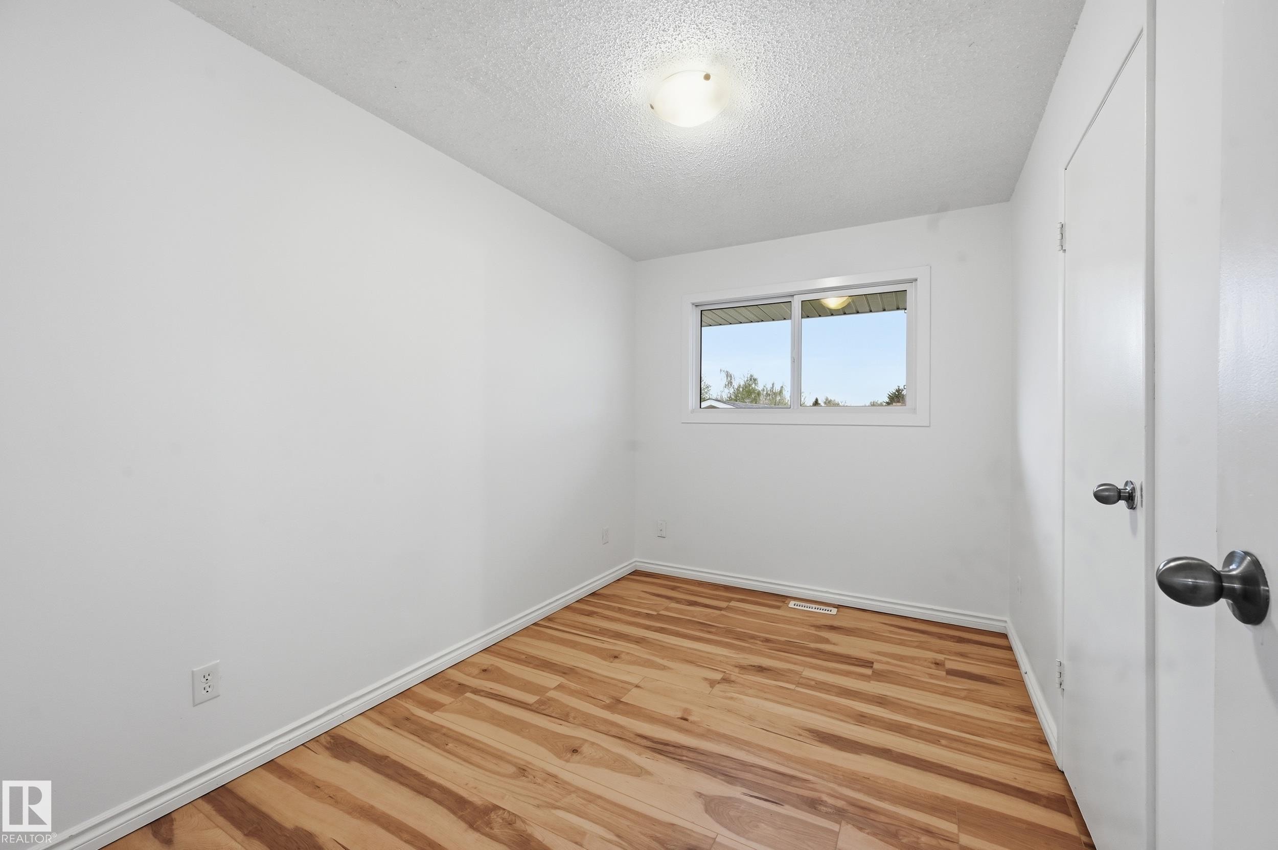 Neutral white walls with wood-finish flooring - 13903 87 Street, Edmonton, AB - Indoor Photo Showing Other Room