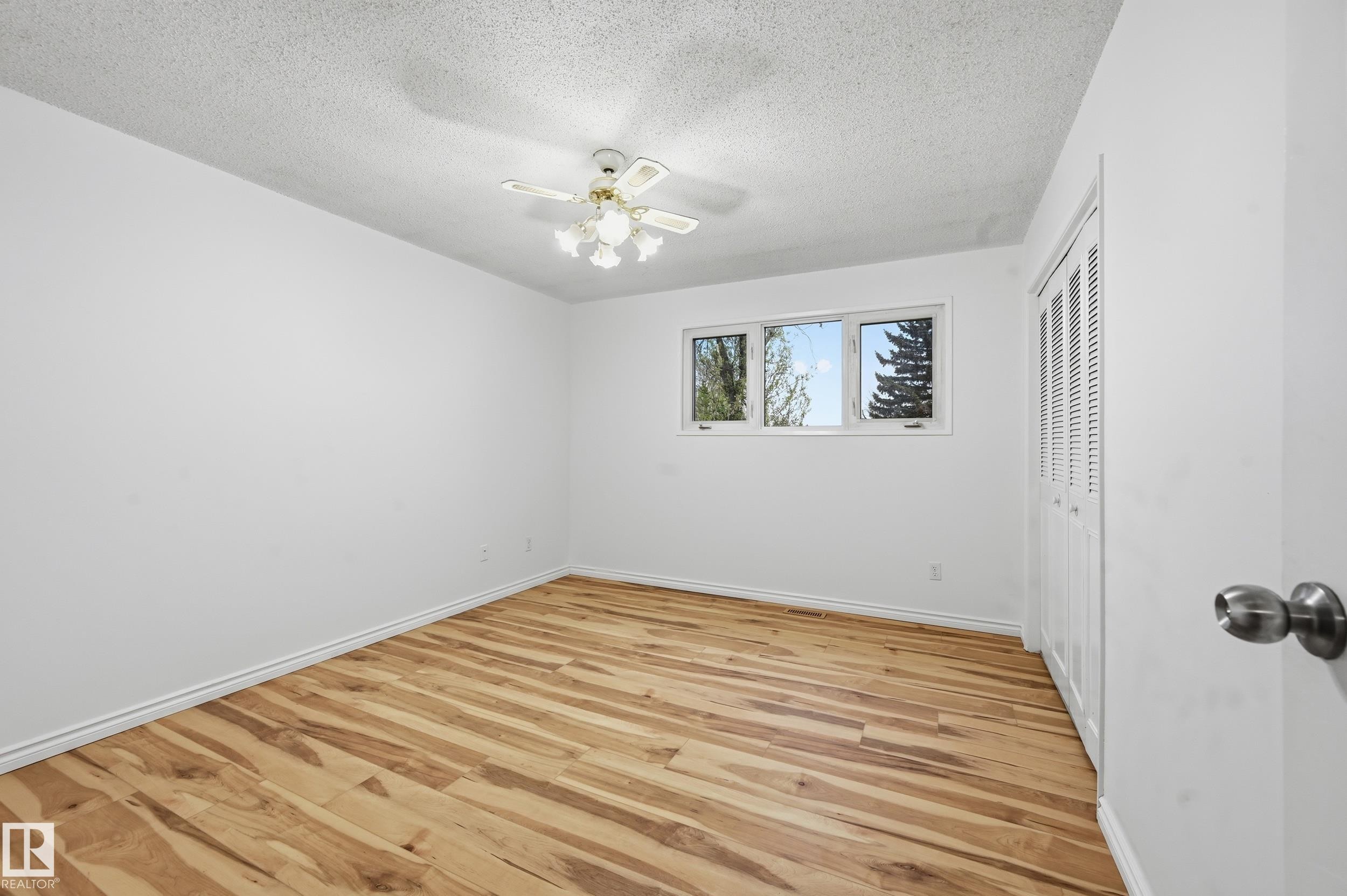 Room featuring wood-finish flooring, white baseboards, and a ceiling fan with integrated lighting - 13903 87 Street, Edmonton, AB - Indoor Photo Showing Other Room